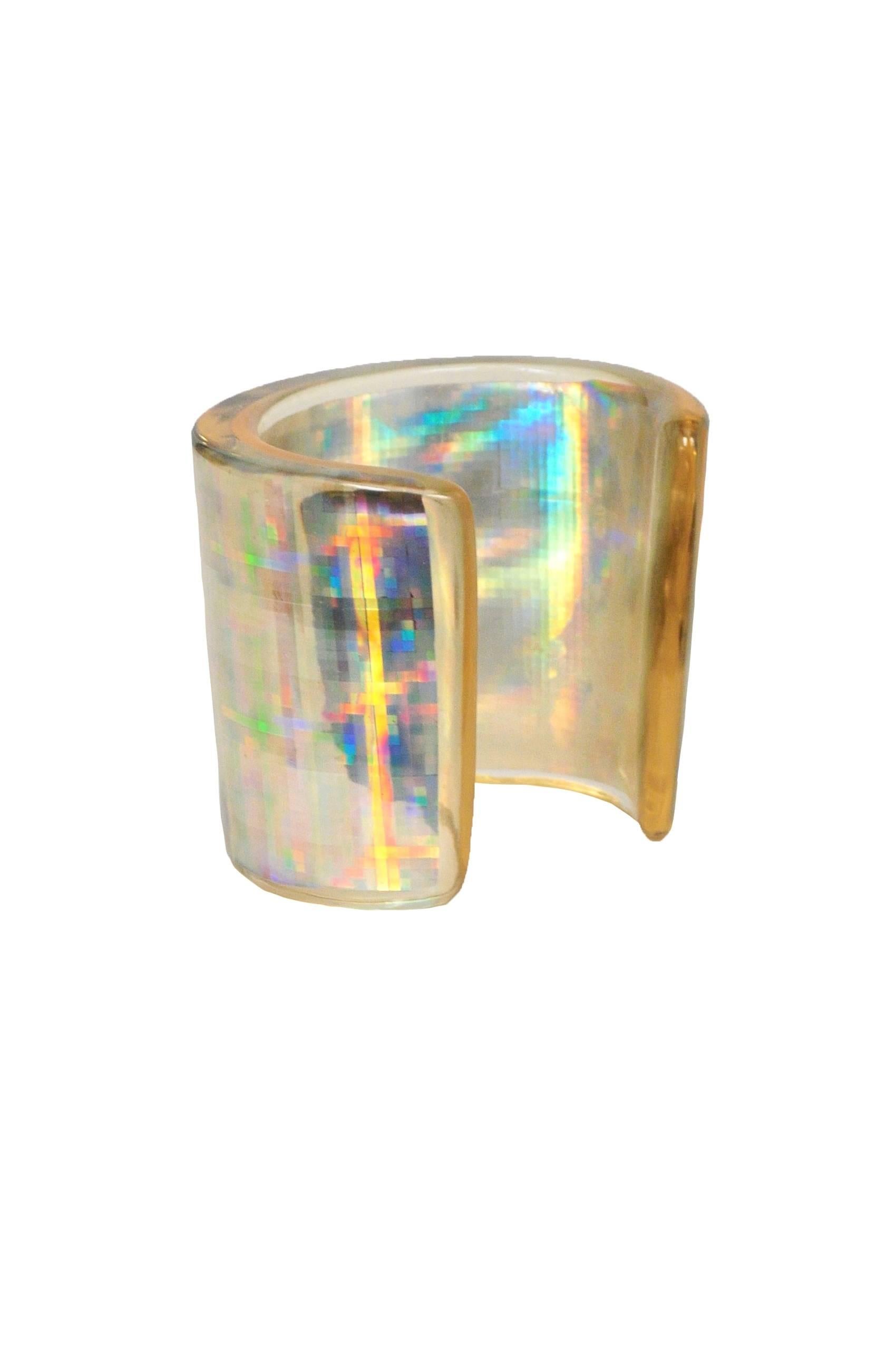 Vintage Chanel acrylic hologram cuff. Large cuff features an iridescent finish and silver tone CC emblem. Stamped Chanel Made in France on back.