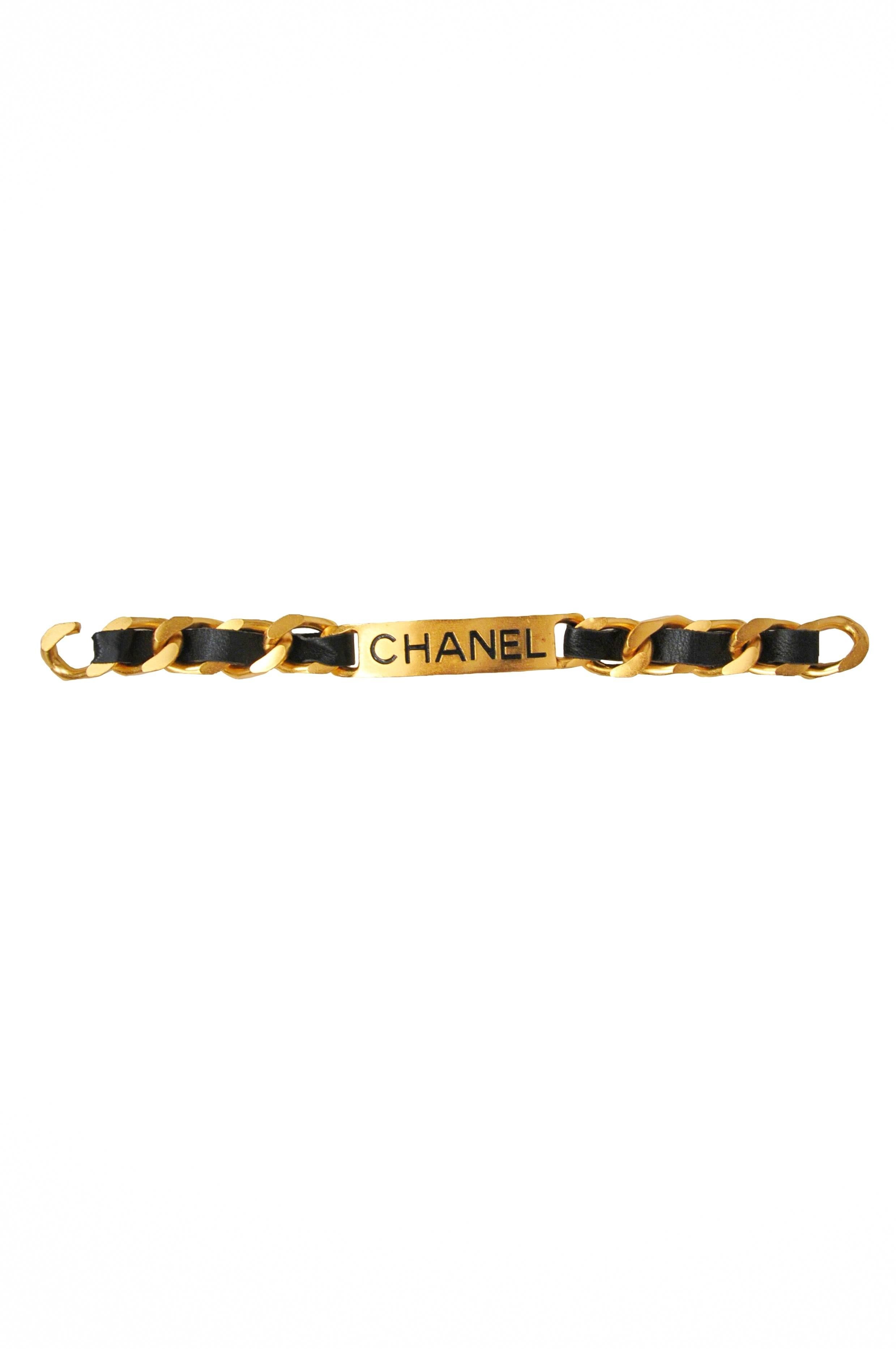 Vintage Chanel ID bracelet. Gold tone metal plate marked CHANEL. Heavy chain with black leather woven throughout. Stamped Chanel Made in France.
