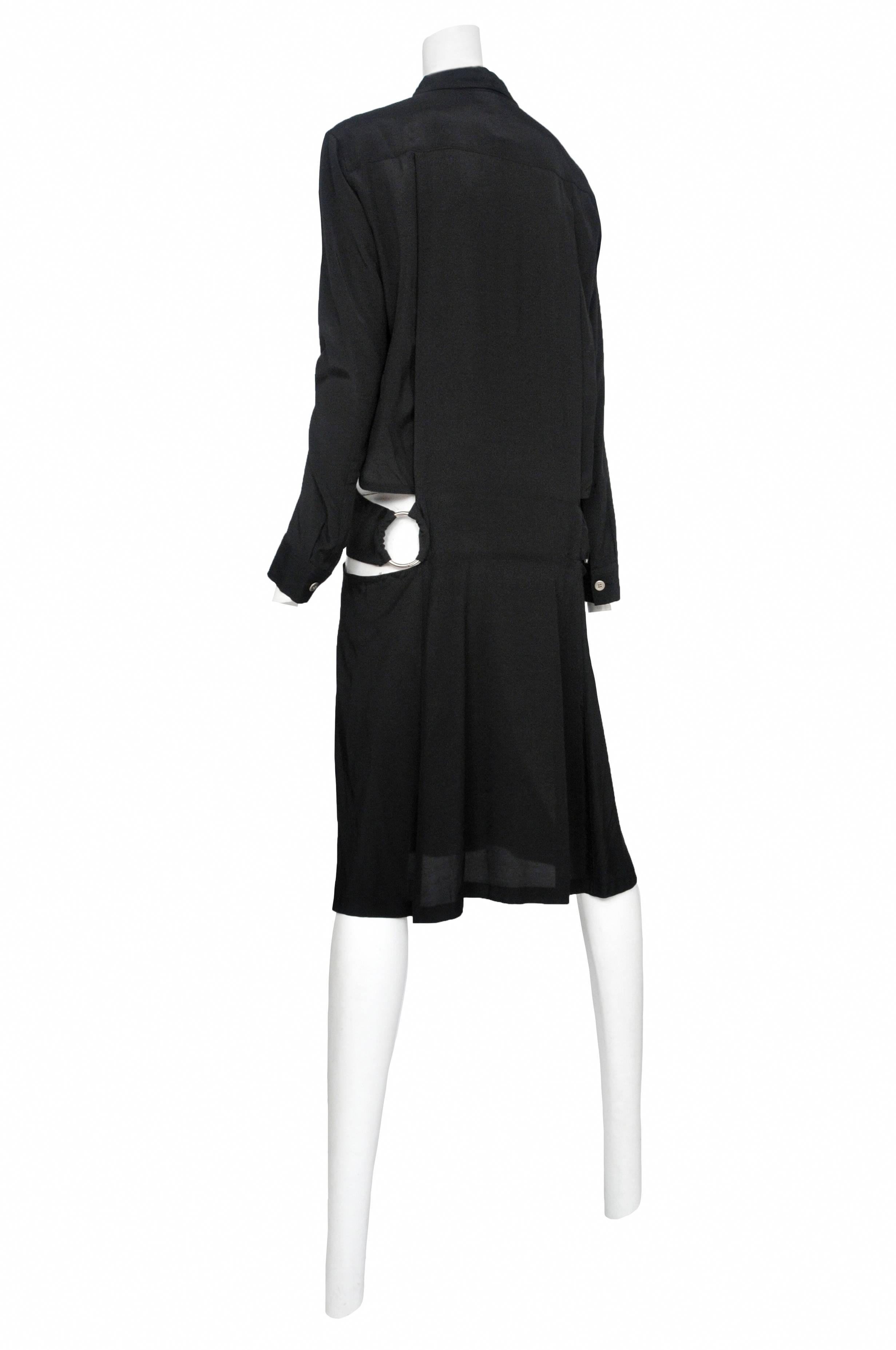 Vintage Yohji Yamamoto black knee length shirt dress featuring white buttons in the center front, cut out details throughout and metal rings toward the back at the waist. 