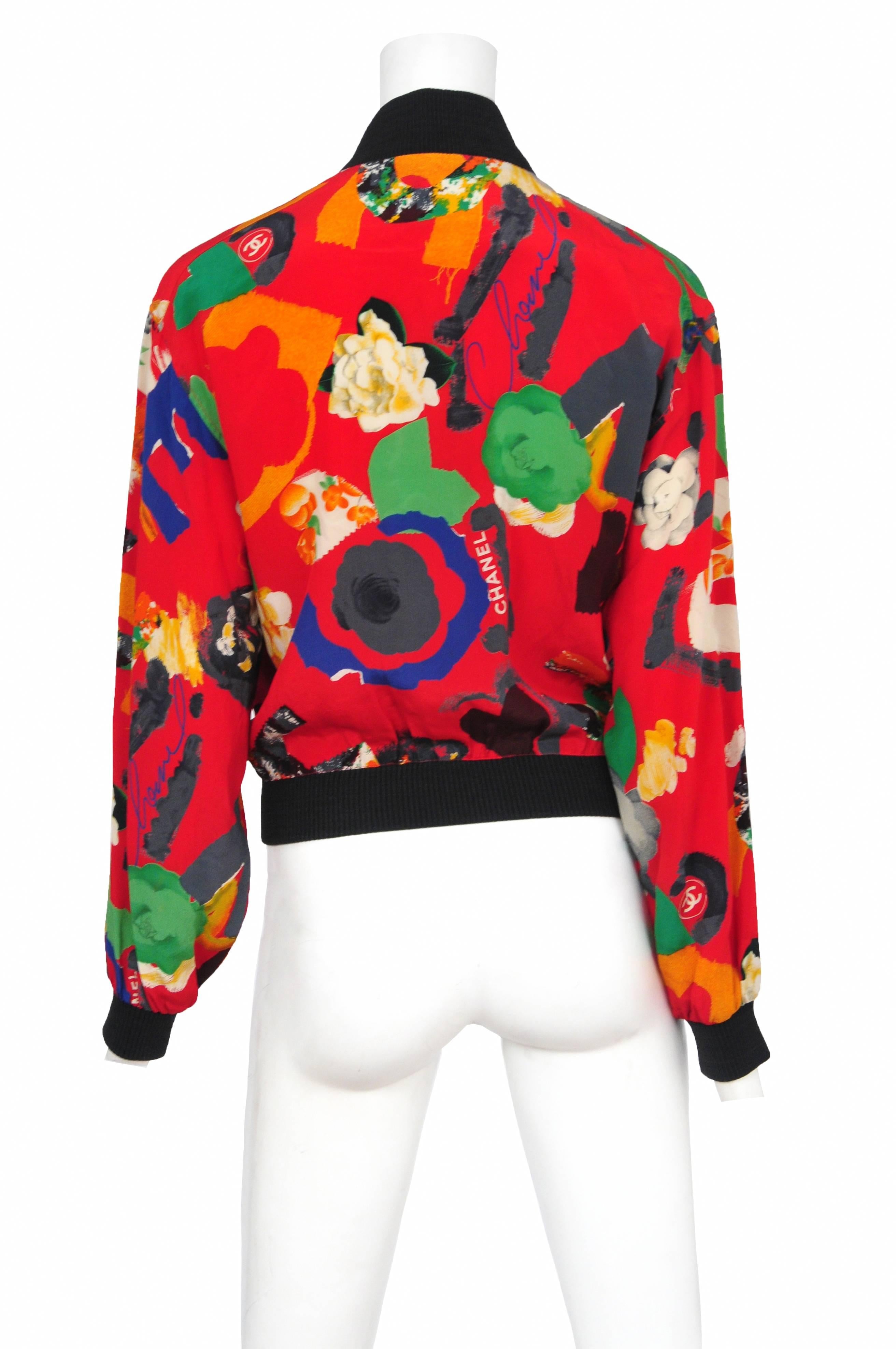 Chanel red silk abstract floral print track jacket with black knit bands and silk front pockets. 
