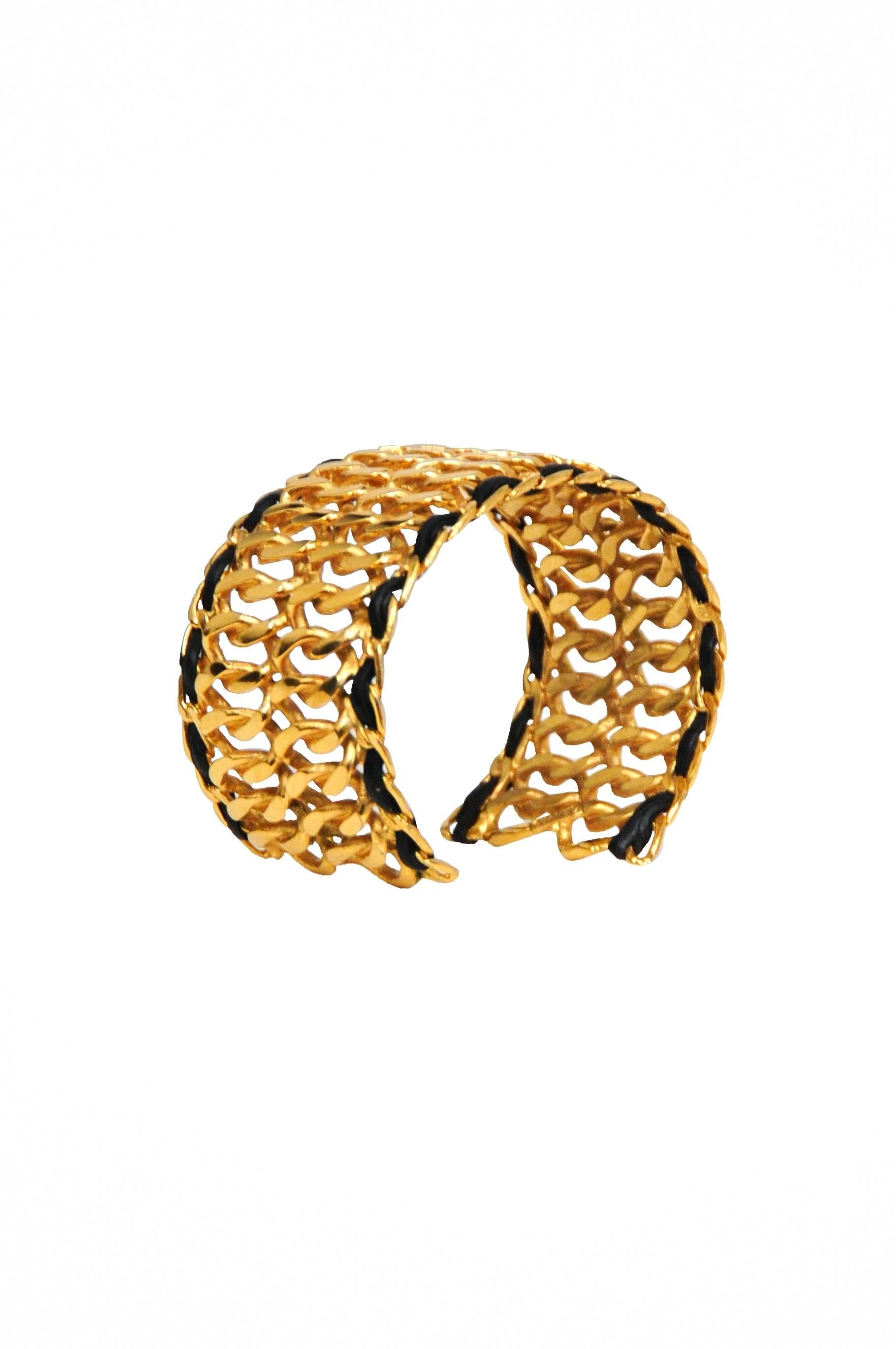 Vintage Chanel gold tone double chain cuff featuring woven black leather along the edges.