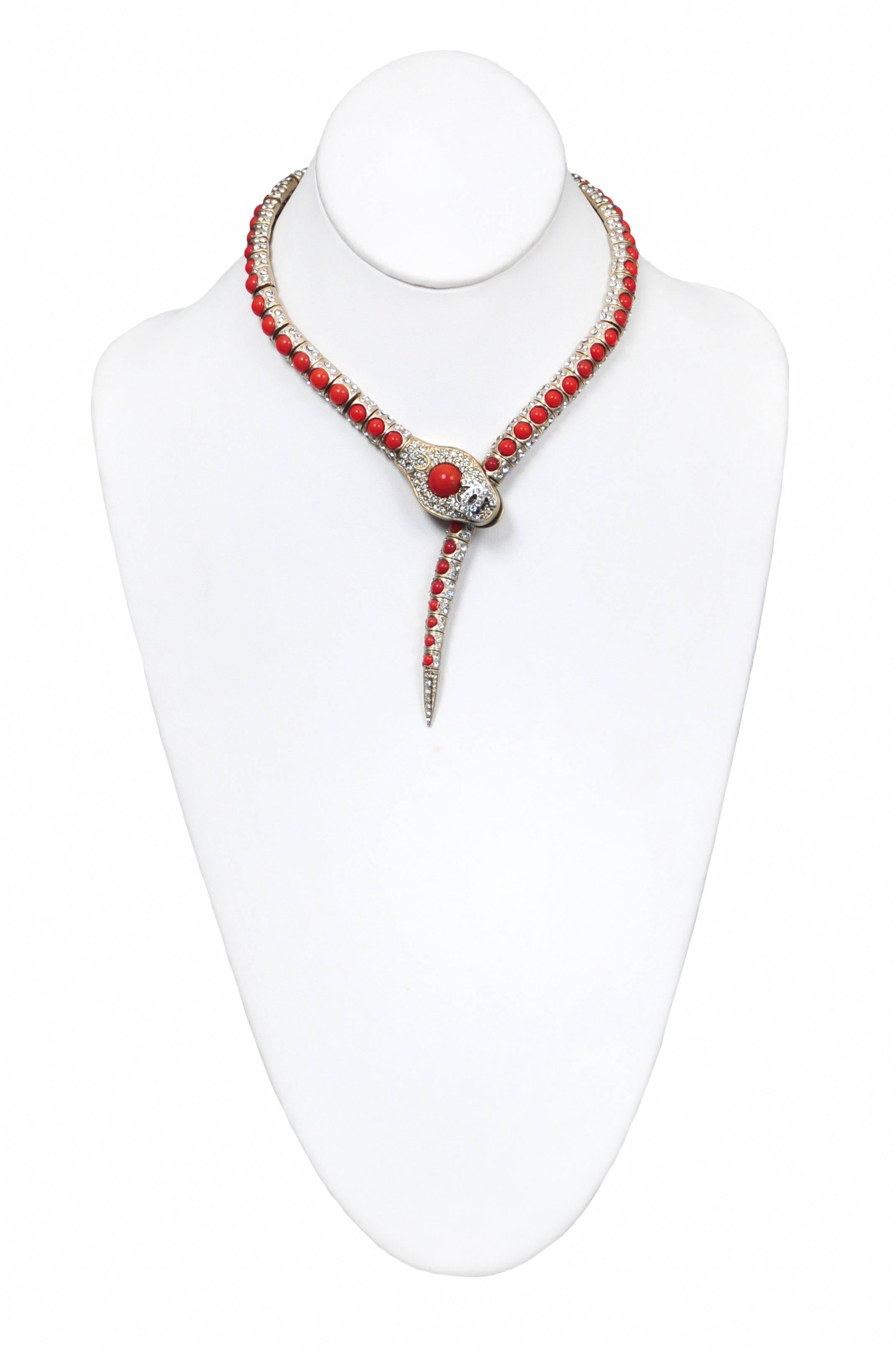Vintage Chanel jeweled snake necklace featuring faux coral cabochons and crystals along the snake body and a faux coral larger cabochon and interlocking crystal CC's dot the snake head.