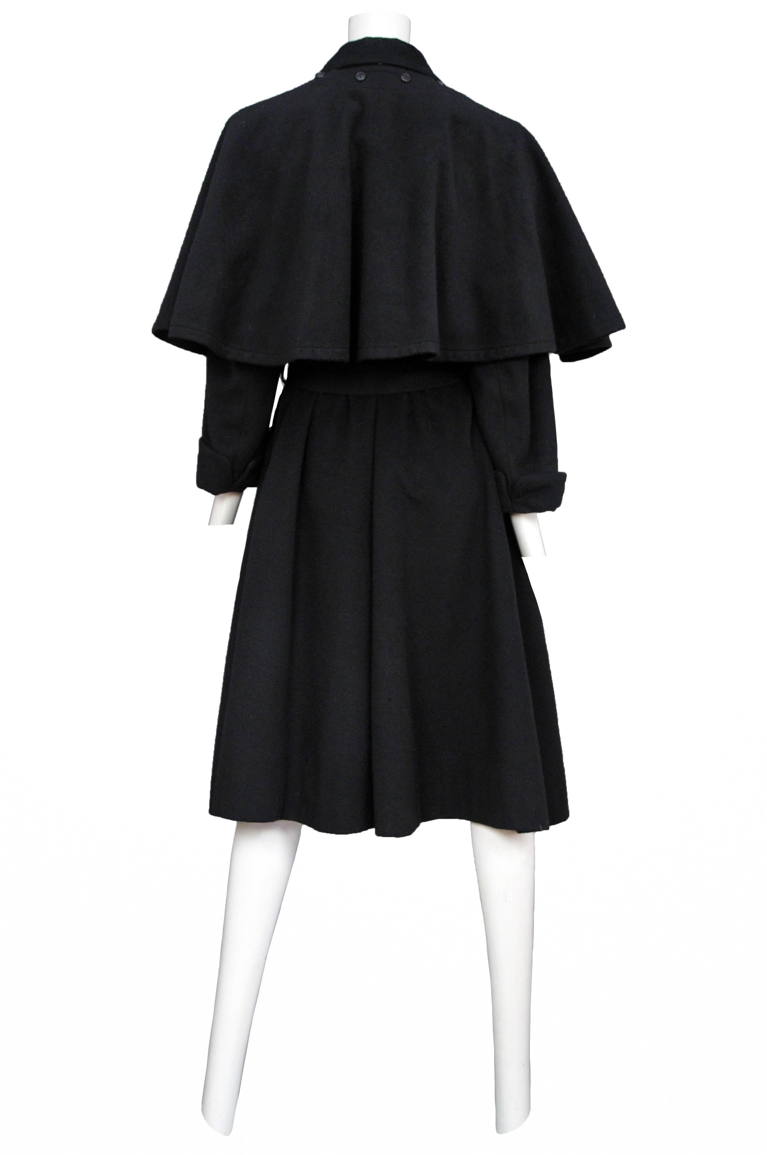 Vintage Yves Saint Laurent black wool double breasted, belted coat featuring side pockets and a removable caplet that sits atop the shoulders and buttons at the nape of the neck.