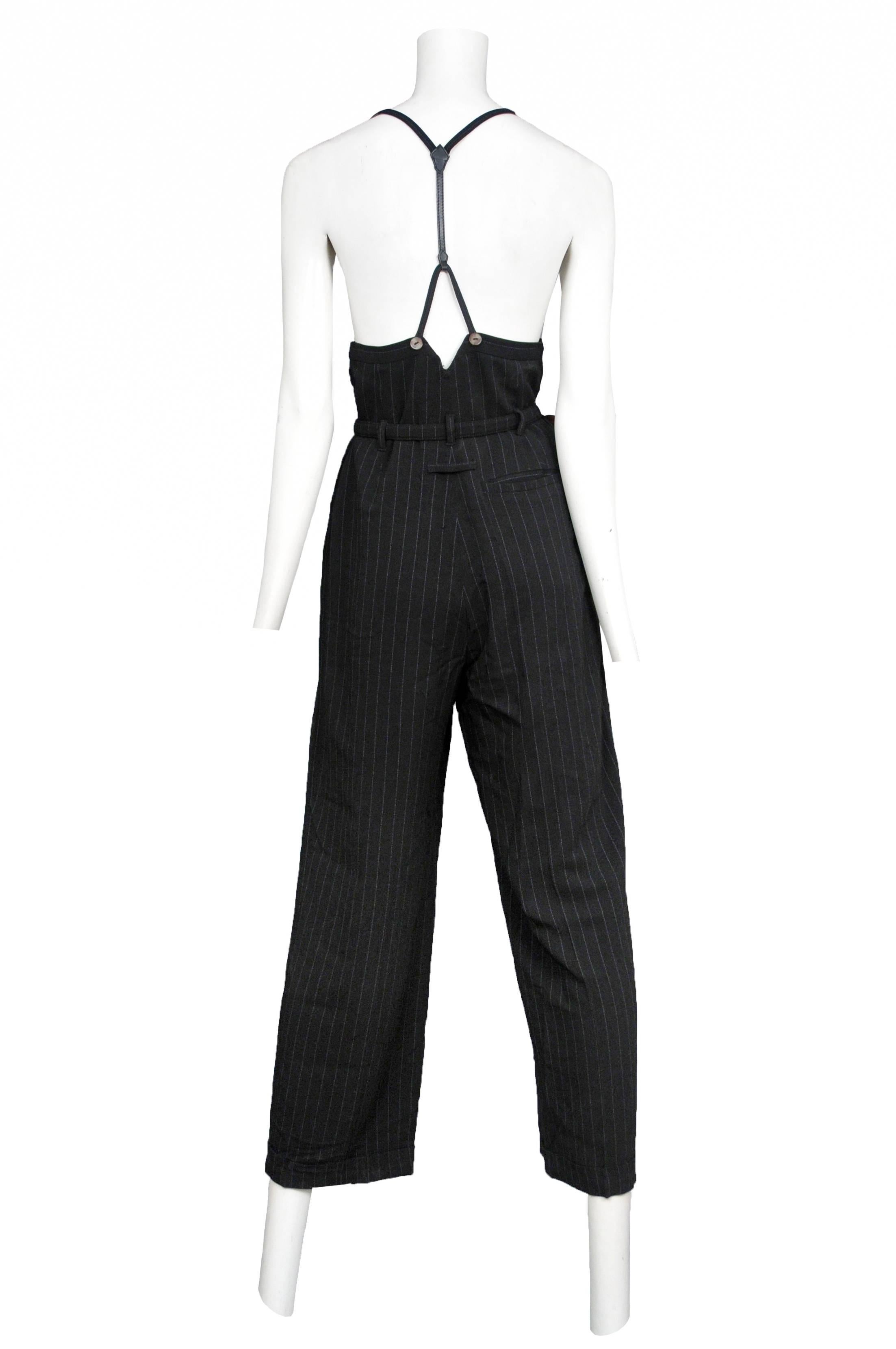 Vintage Jean Paul Gaultier dark grey pinstripe high waisted, belted trousers featuring suspenders that attach at the front and in a racerback fashion in the back. 