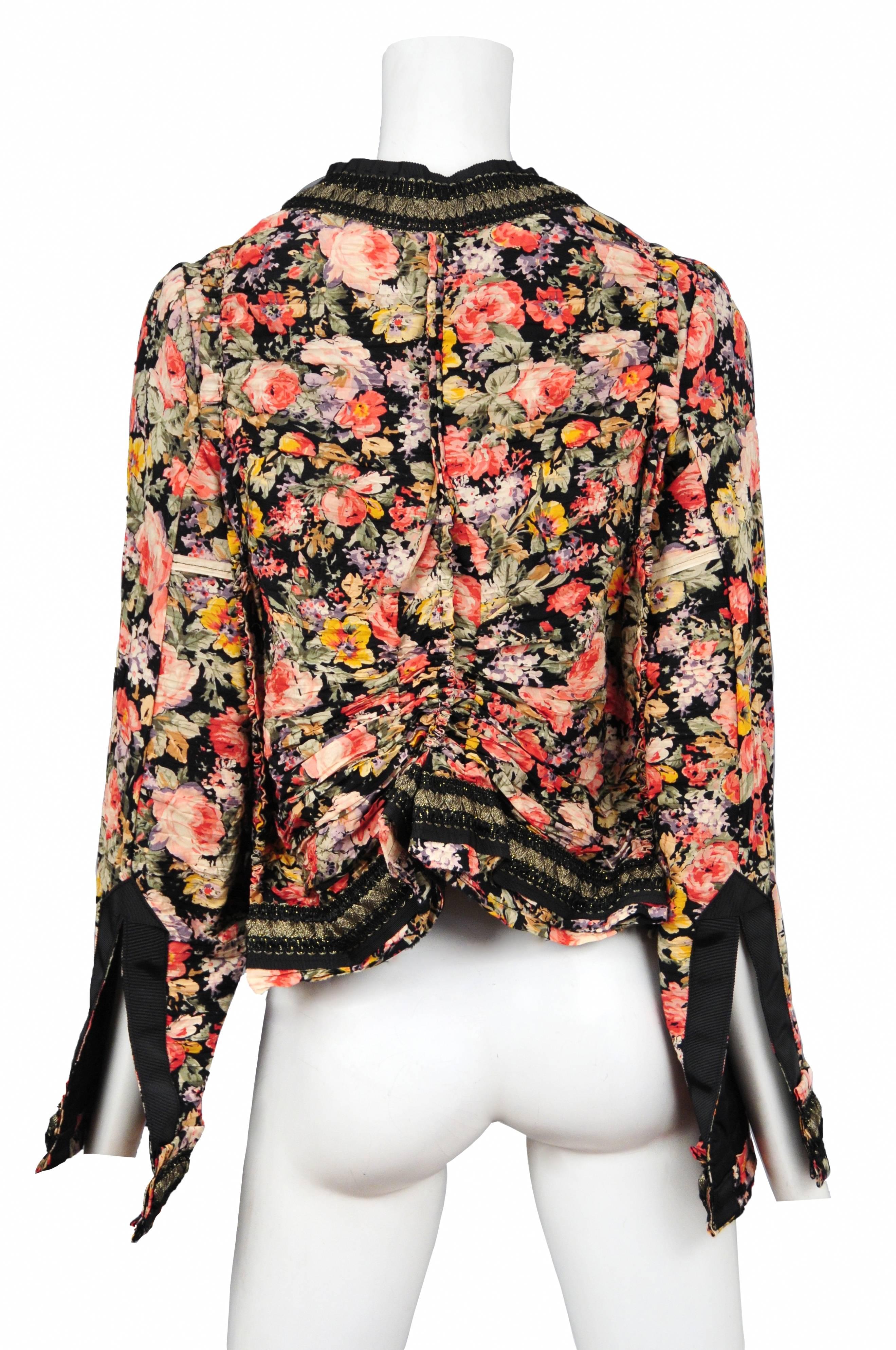 Vintage Comme des Garcons multicolor floral printed jacket featuring front pockets and gold and black braided trim along the edges. Circa 2007.