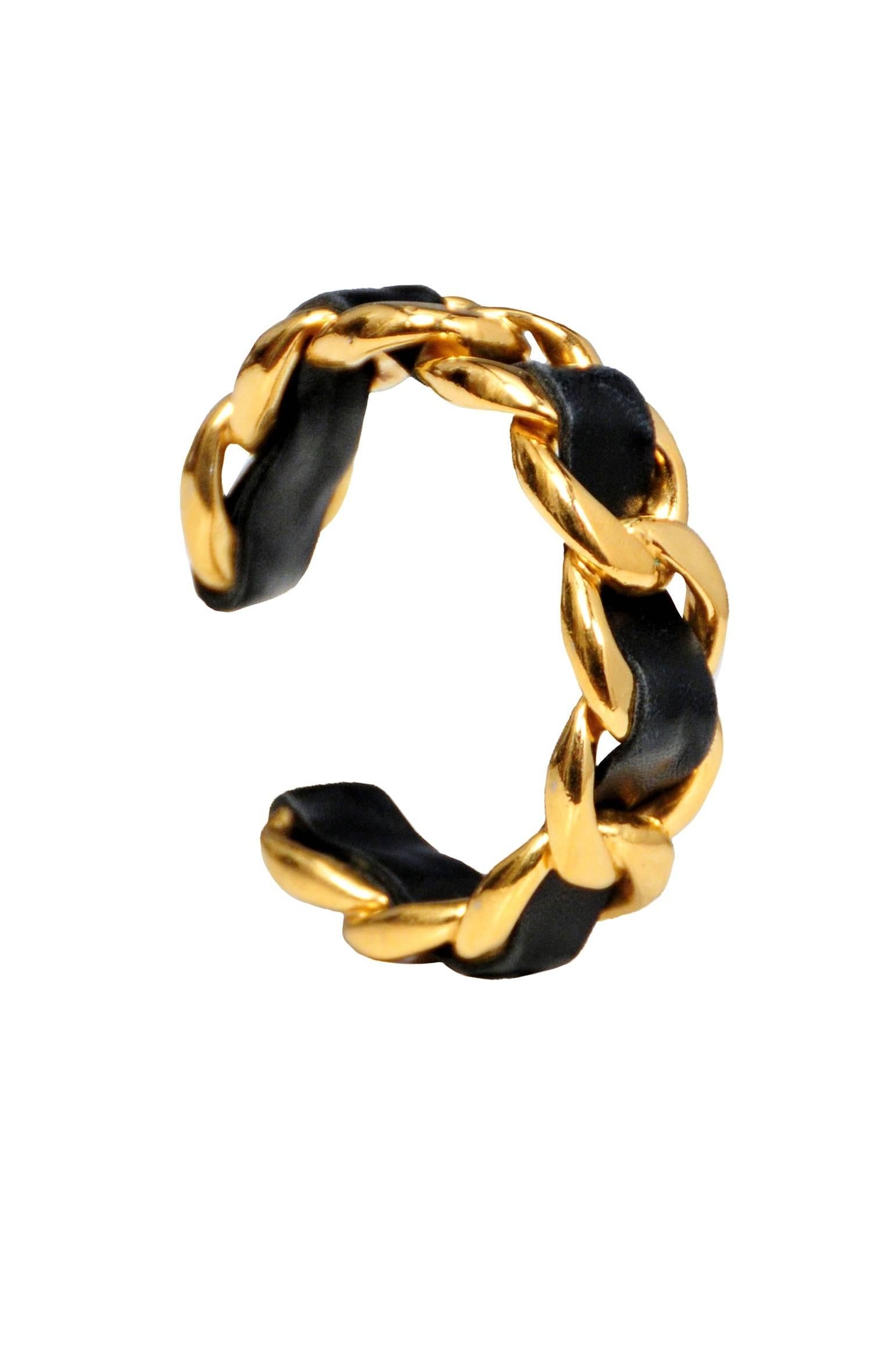 Vintage Chanel gold tone chain bracelet featuring black leather braided through, resembling the iconic braided chain straps on Chanel handbags.