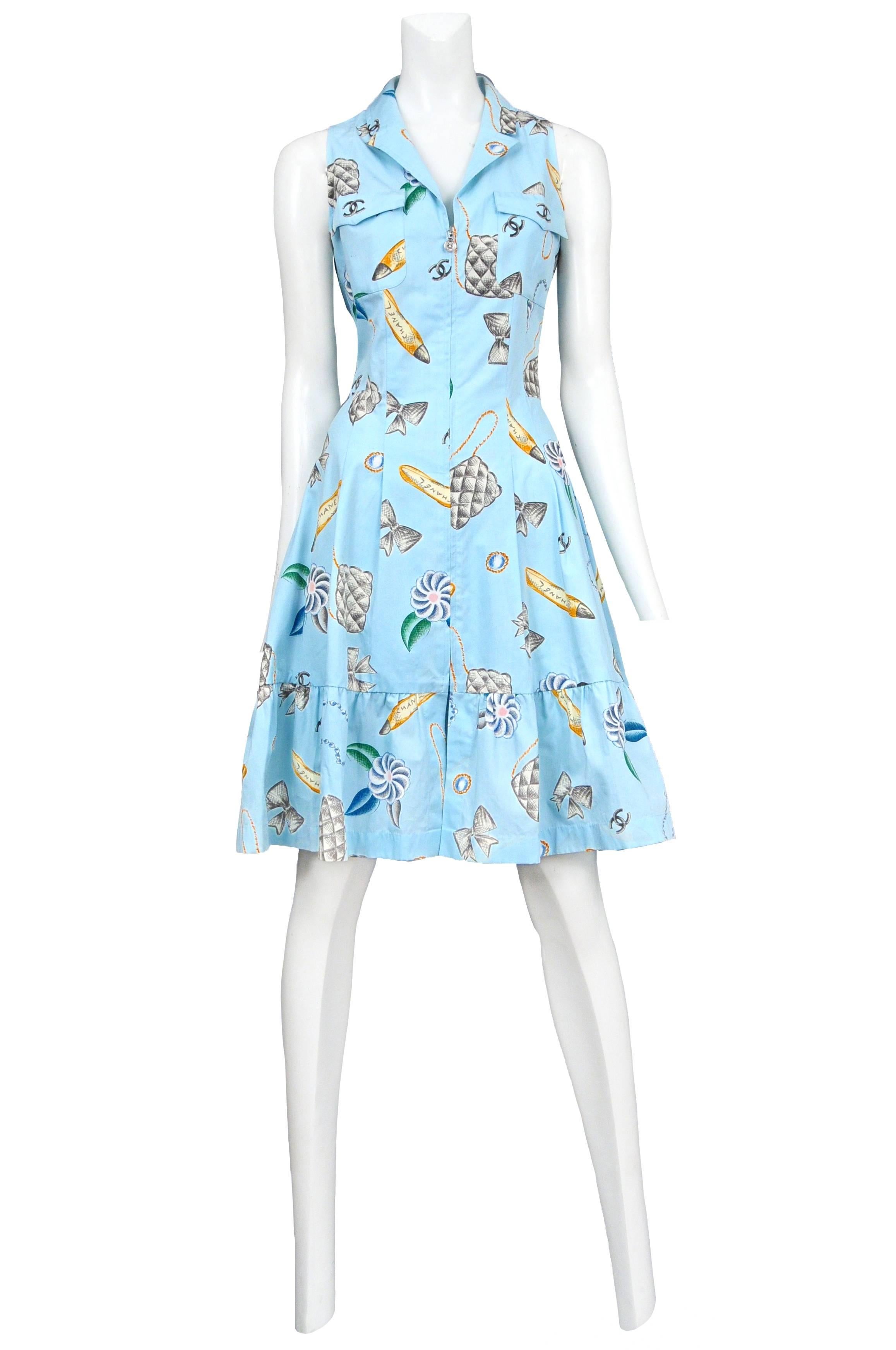 Vintage Chanel blue cotton sleeveless shirt dress featuring chest pockets, a front zipper closure, a flounce at the hem and an allover floral bag, bow and shoe print. Please contact for additional photos. 