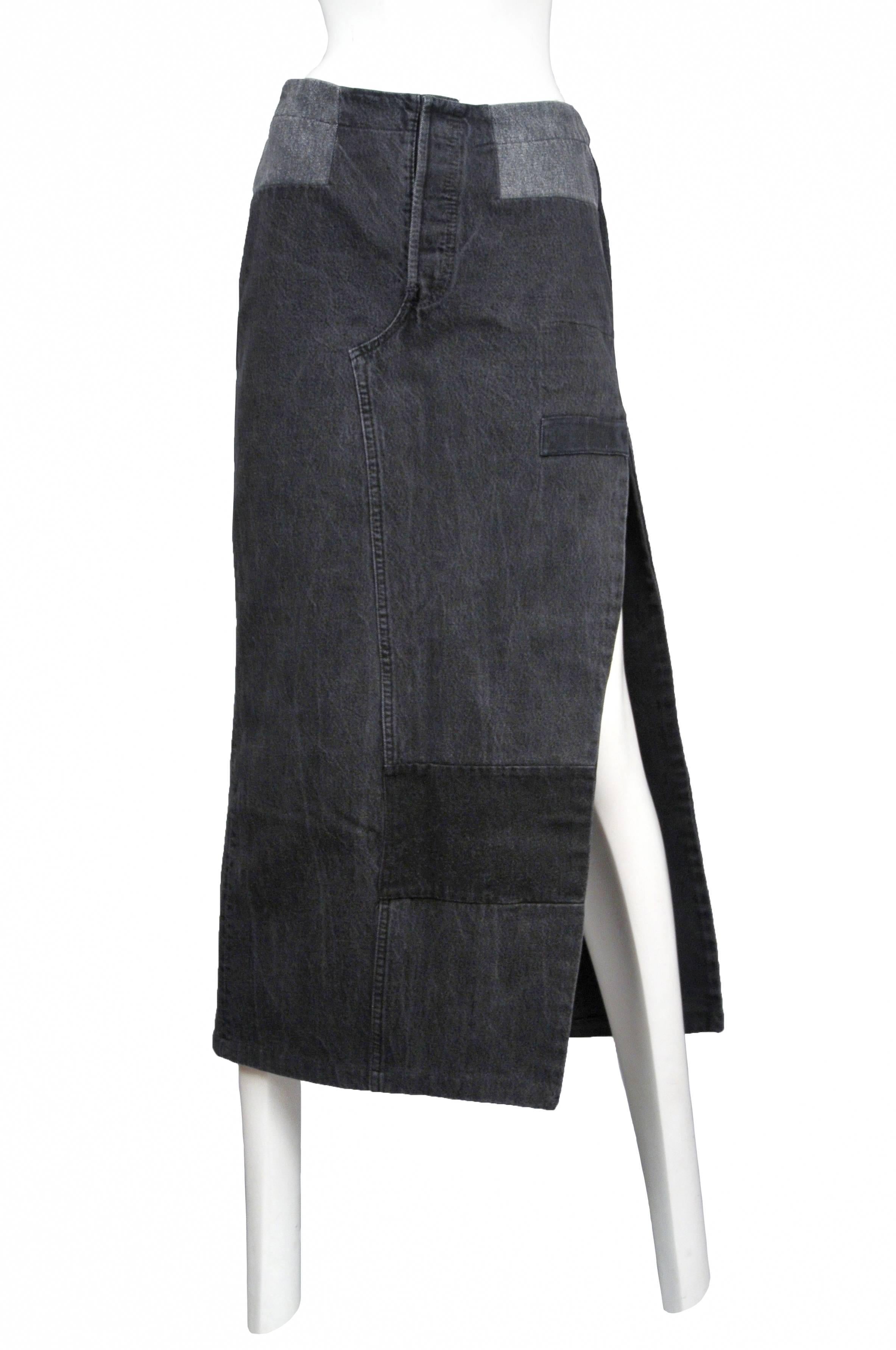 Vintage Martin Margiela artisanal black denim maxi skirt made of reconstructed black jeans and features a slit at the side and inset back waistband. Circa 2002.