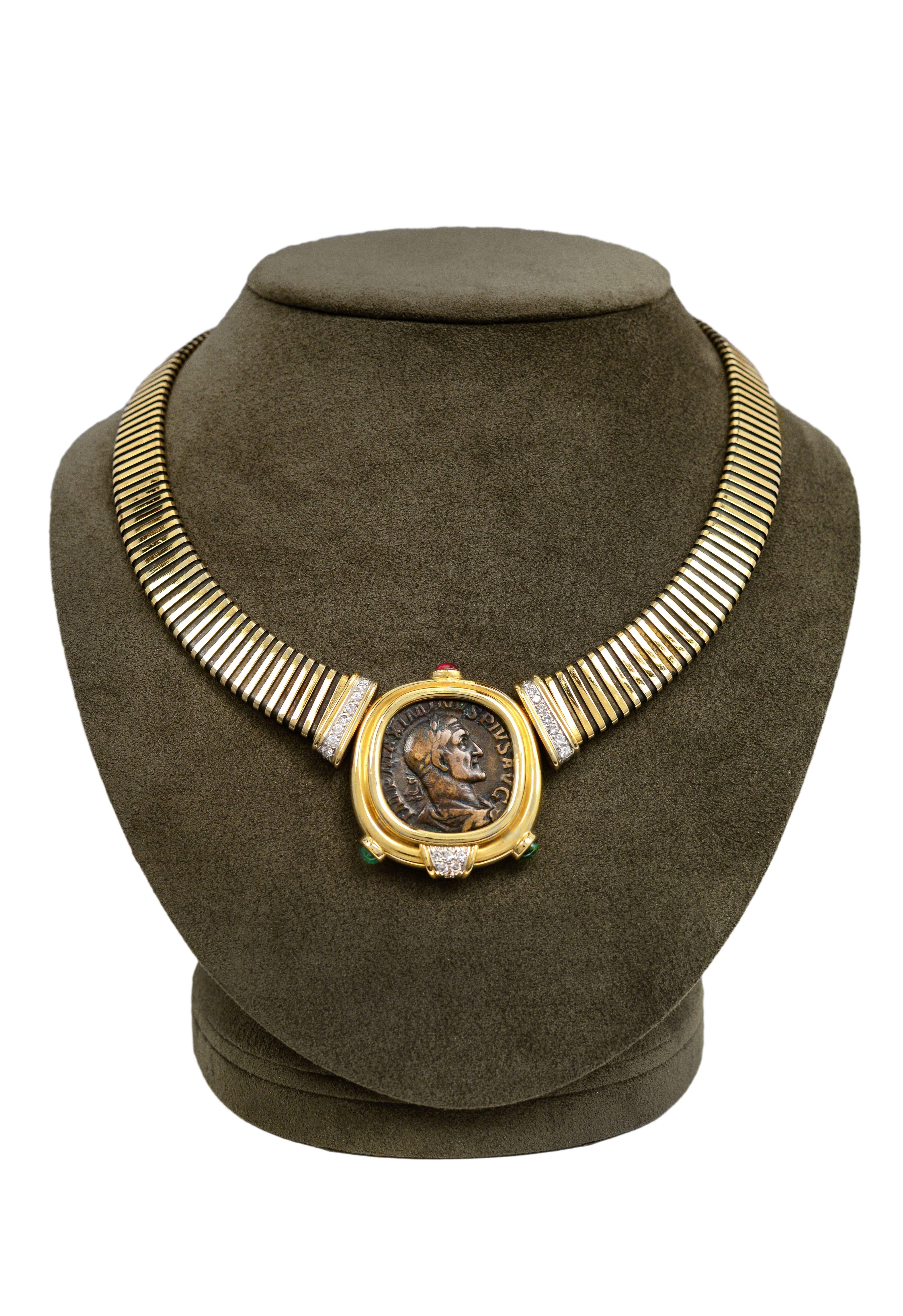 A stunning and highly-stylized Bulgari Monete necklace with semi rubies, emeralds and diamonds. The necklace features a large ancient coin with 18K gold bezel and Tubogas coil. Stamped BULGARI on reverse of bezel. Necklace circa 1980's. 

*Please