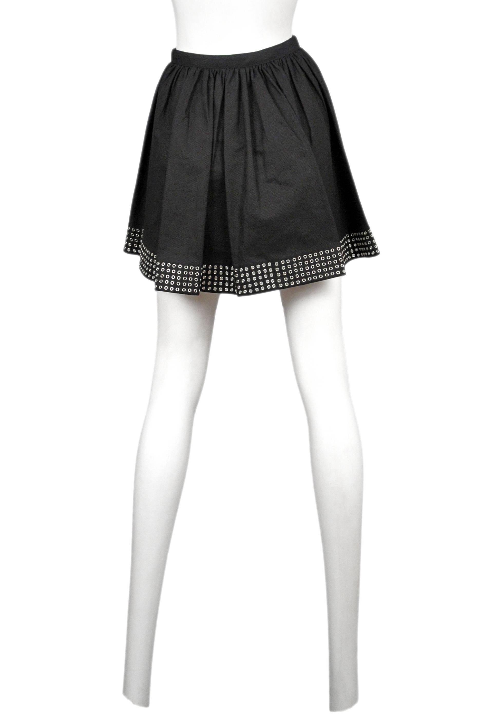 Azzedine Alaia black cotton mini circle skirt with silver grommet trim. Skirt has a one button closure and open front. 