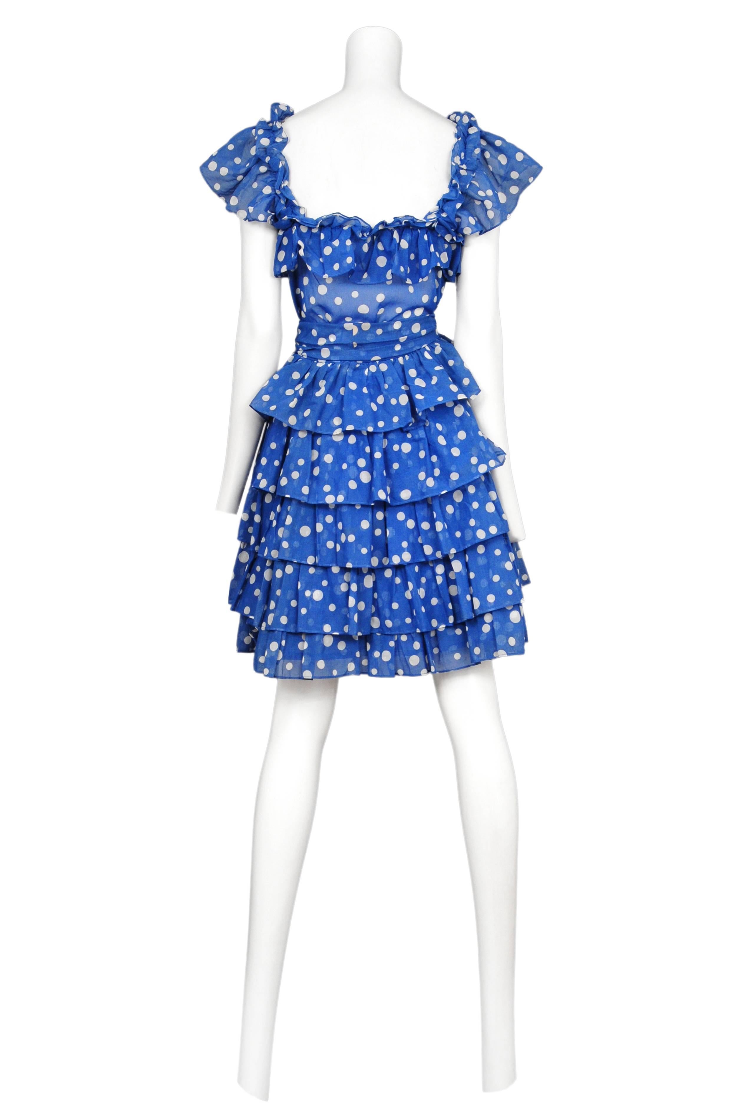Vintage Yves Saint Laurent blue and white cotton polkadot ensemble featuring a ruffle trim cap sleeve blouse, a multi-tiered ruffle skirt and matching waist sash.