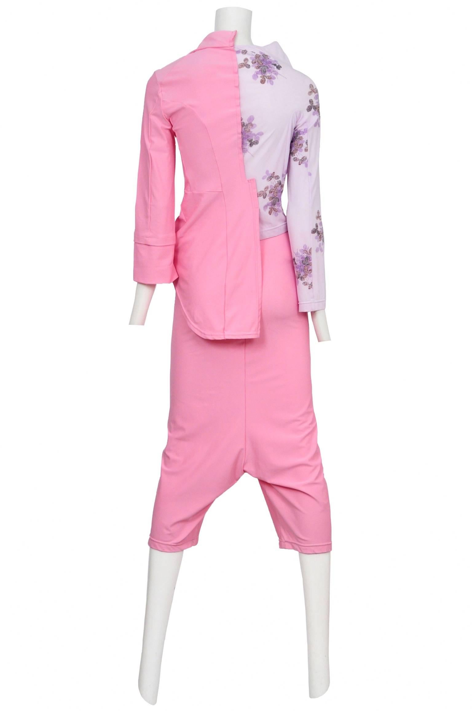 Vintage Comme des Garcons ensemble featuring a long sleeve top with one side made out of a lilac floral print and the other, in a shade of bubble gum pink, in the shape of a jacket. The matching bubble gum pink pants are drop crotch in style and