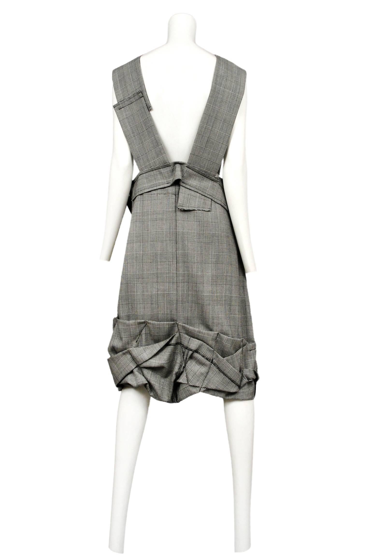 Vintage Comme des Garcons black and white check knee length dress featuring an apron style bodice, and ornate stitched down pleating at the waist and hem.

Please email us for additional photos.