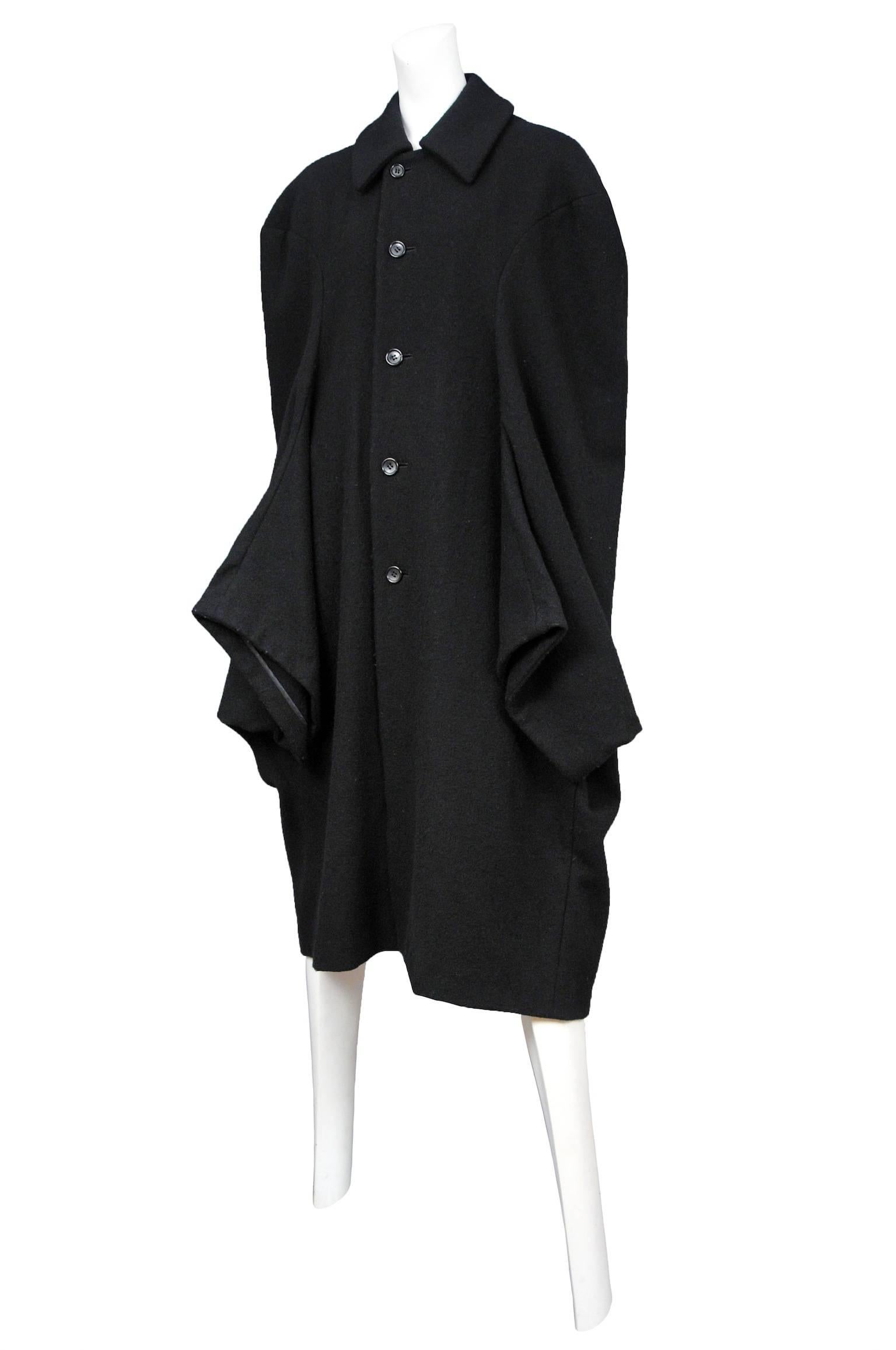 Vintage Comme des Garcons black wool button front coat featuring cape like sleeves at the lower front. Circa 1995.

Please contact us for additional photos.