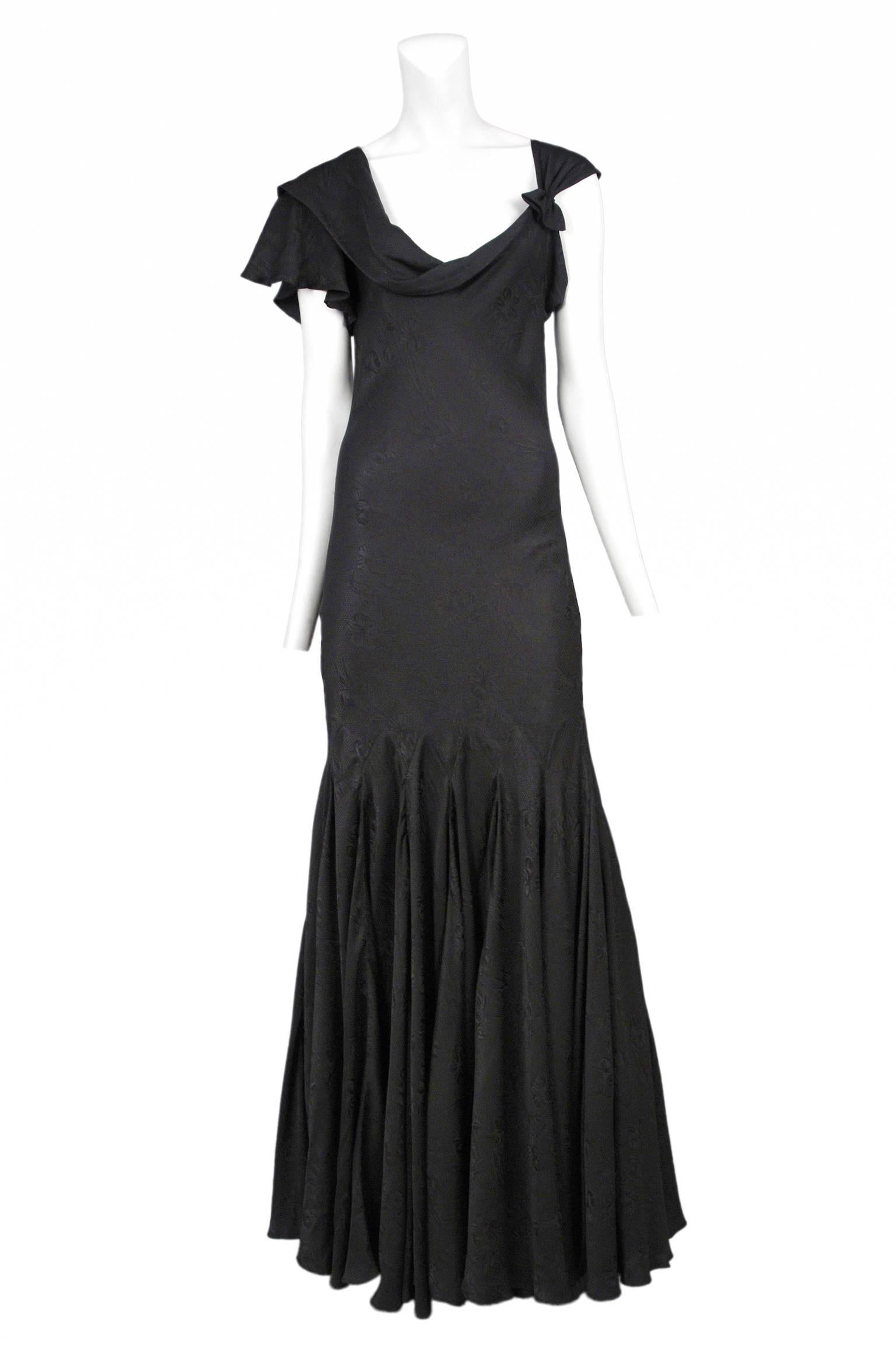 Vintage Alexander McQueen black silk gown with asymmetrical neckline, flutter sleeve, godet pleats at skirt and tonal floral pattern throughout. From the Sarabande Spring / Summer 2007 Collection.