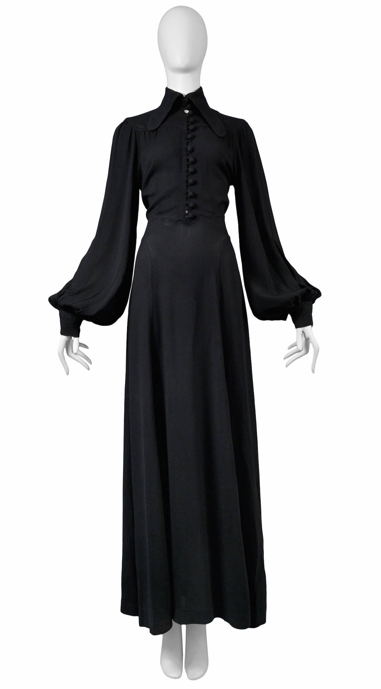 Vintage Ossie Clark black crepe gown featuring an elongated collar, bell sleeves, a tie at the back waist and a covered button front opening.
Please inquire for additional images and measurements.