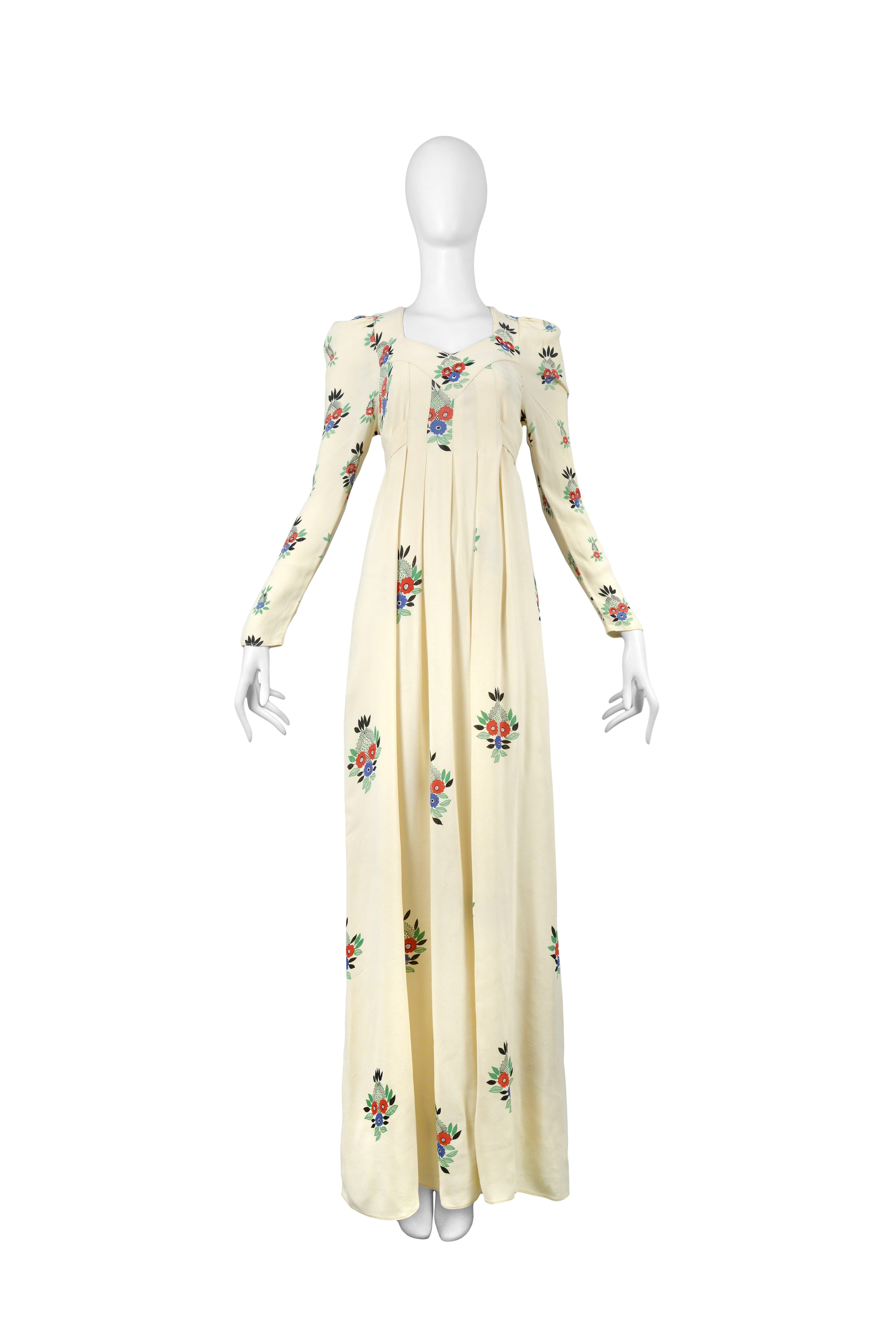 Vintage original Ossie Clark long sleeve moss crepe ivory gown featuring a knife pleated empire waist, a built in sash that ties in the back and an allover red, blue and green floral bouquet print by famed textile designer Celia Birtwell. One Ossie