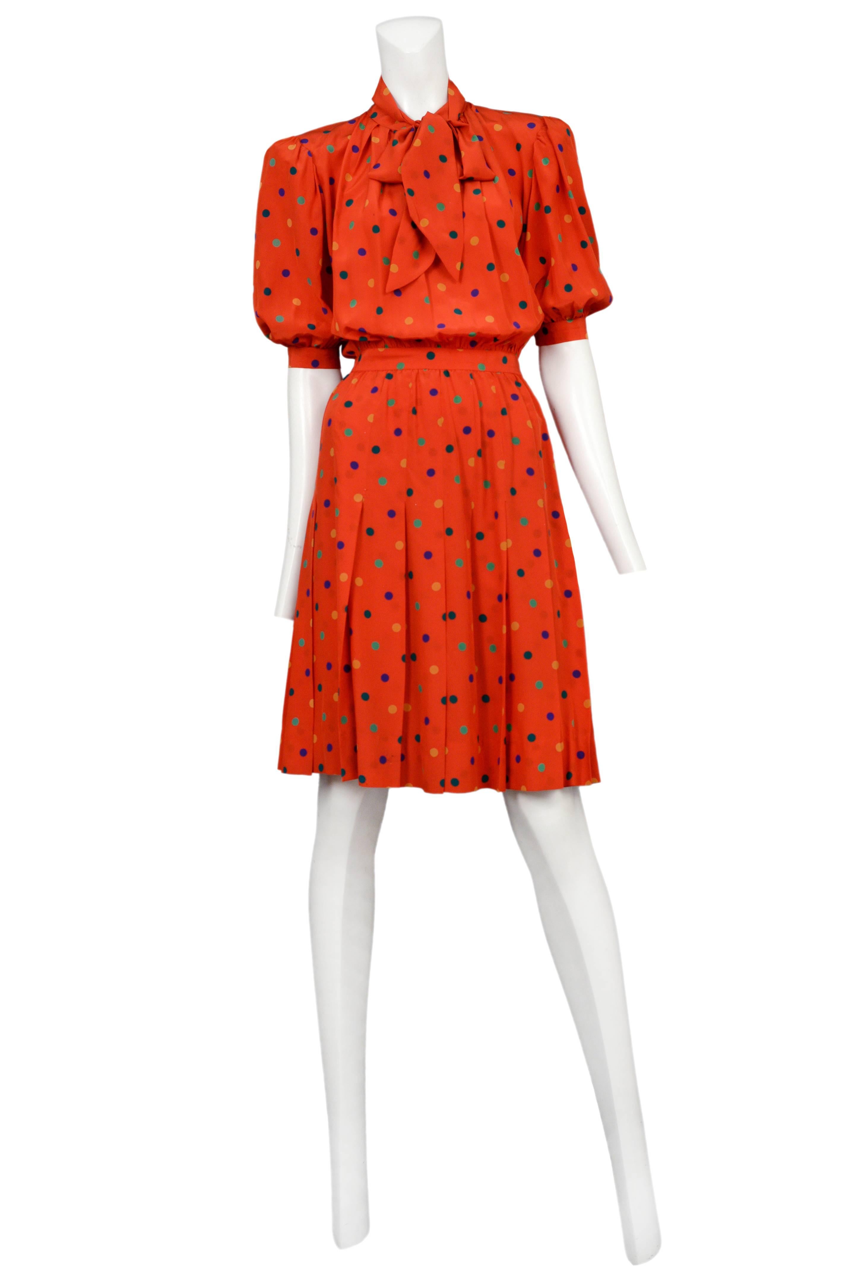 Vintage Yves Saint Laurent red silk knee length day dress featuring pleats at the skirt, a built in waistband, short sleeves, a built in bow at the collar and an allover multicolor polka dot print.
Please inquire for additional images.