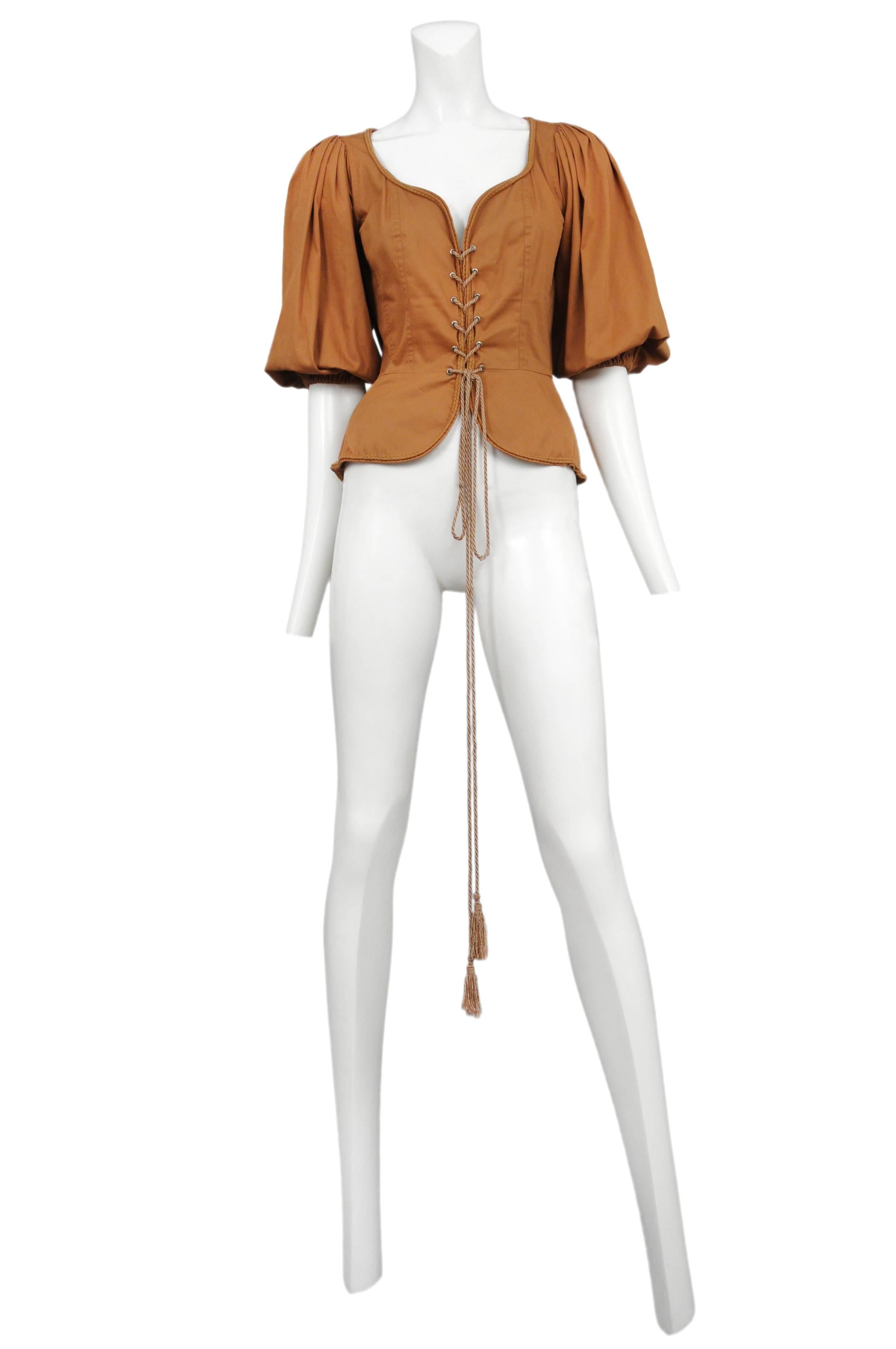 Vintage Yves Saint Laurent khaki safari corset peasant top featuring a built in peplum below the waist, tassel cording lacing up the front and full peasant style sleeves.
Please inquire for additional images.