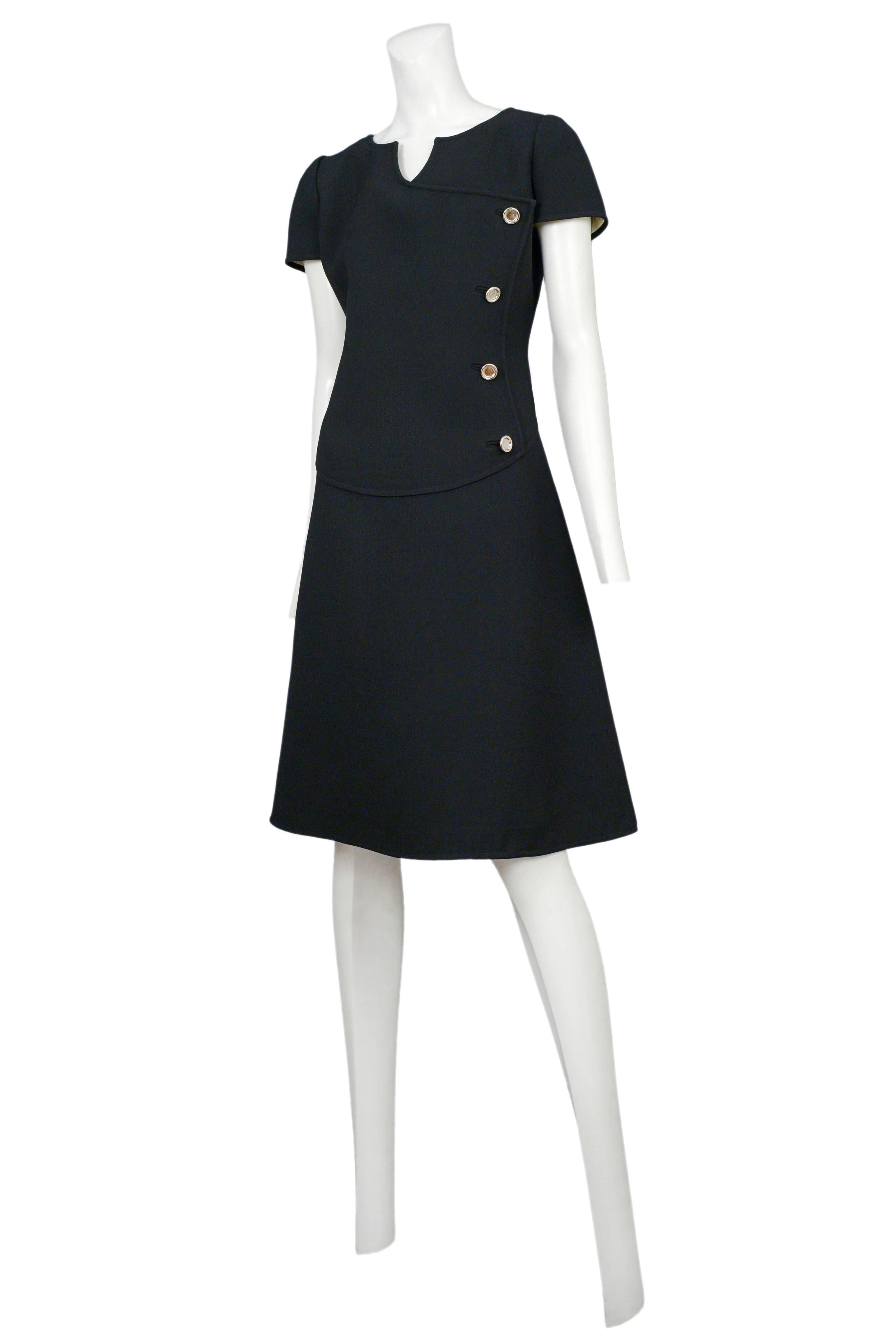 Vintage Courreges black knee length wool day dress featuring four silver side buttons and short sleeves. 
Please inquire for additional images.