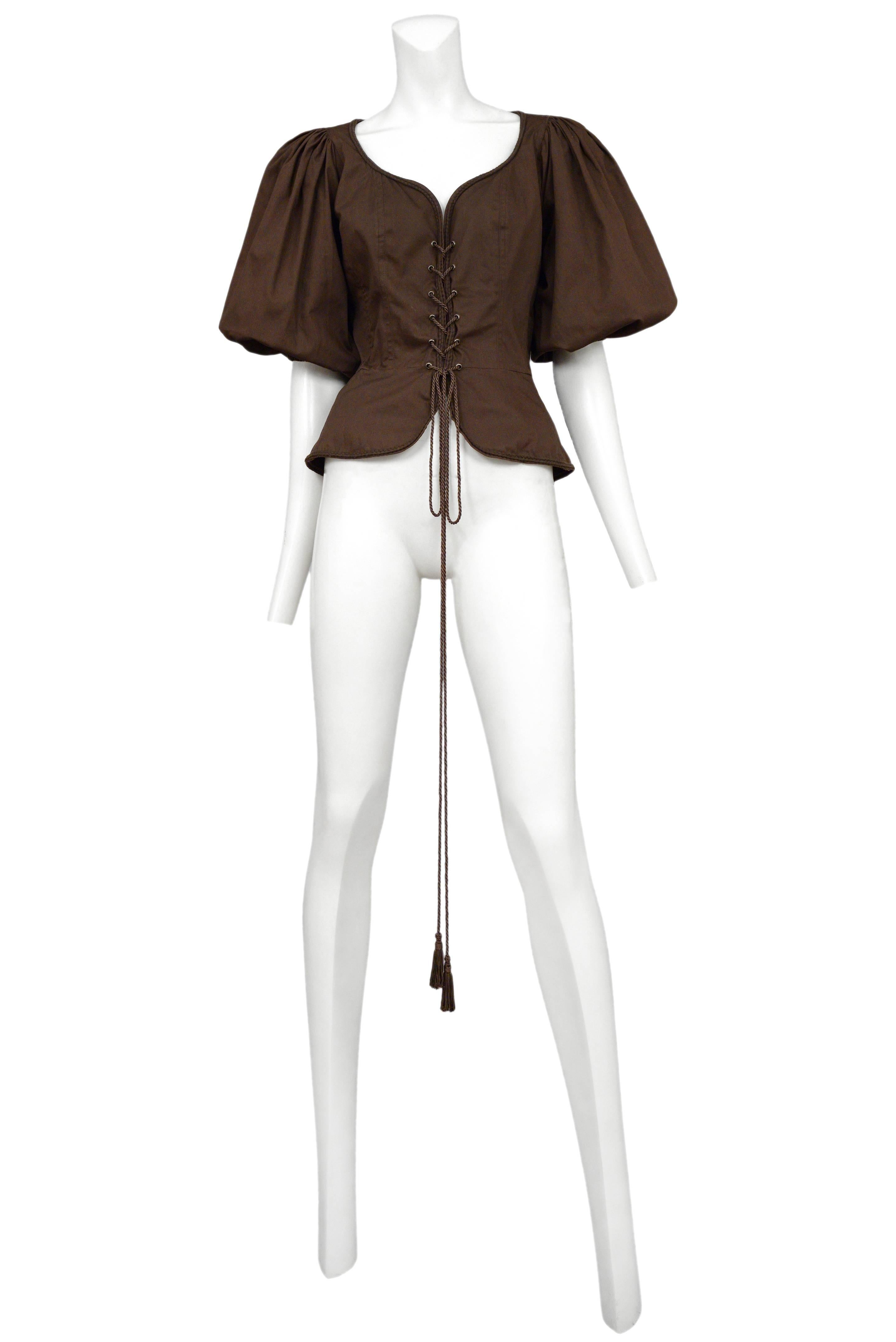Vintage Yves Saint Laurent brown safari corset peasant top featuring a built in peplum below the waist, tassel cording lacing up the front and full peasant style sleeves.
Please inquire for additional images.