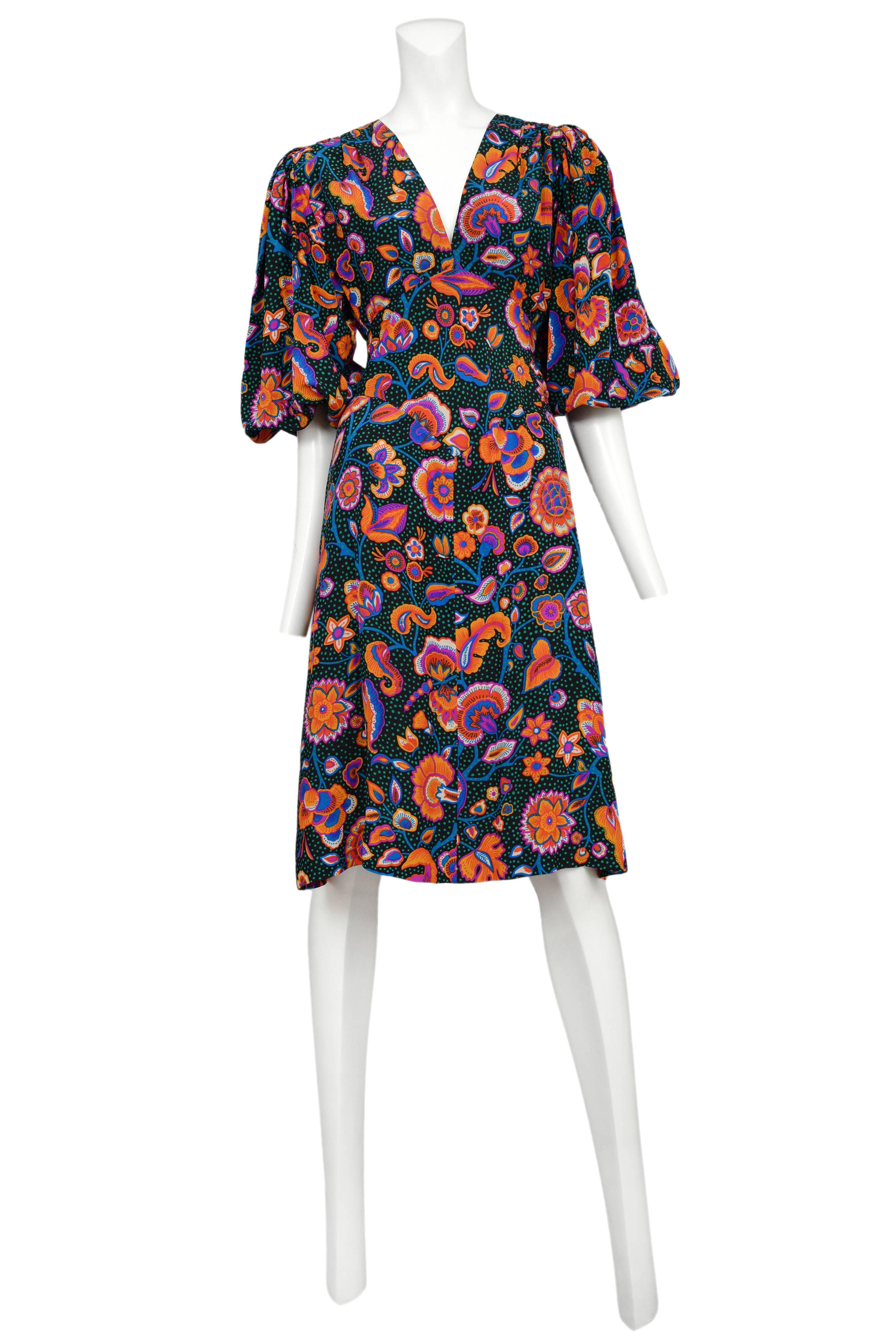 Vintage Yves Saint Laurent silk day dress featuring peasant style sleeves, a v-neckline, a tie at the center back waist and an allover orange, pink and blue flower print interspersed with green dots.
Please inquire for additional images.