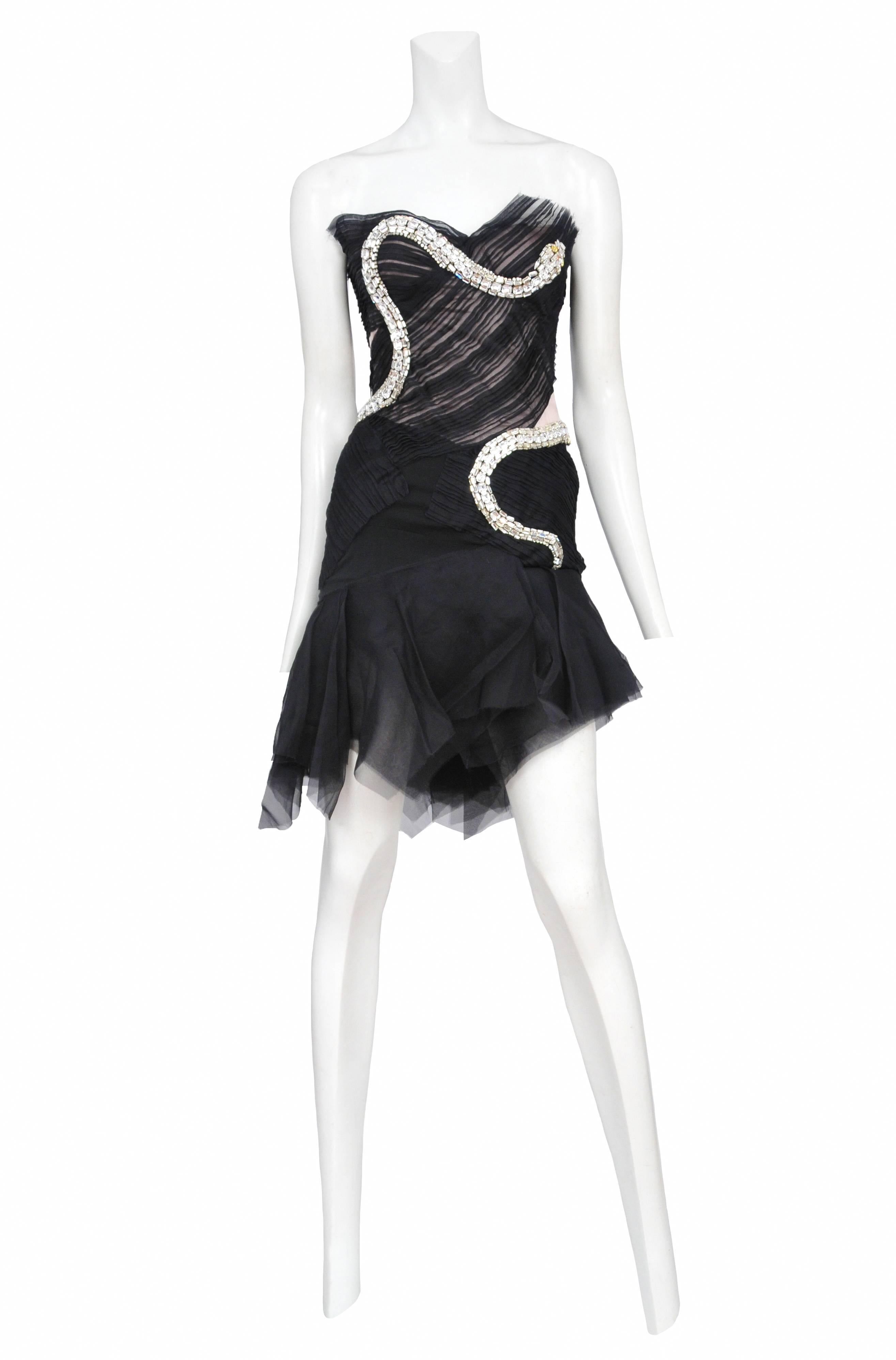 Vintage Tom Ford for Gucci black organza strapless pleated cocktail dress with asymmetrical ruffles at the hem and is adorned with a rhinestone snake that wraps around the bodice and hips. Circa Spring 2004.
Please inquire for additional images.