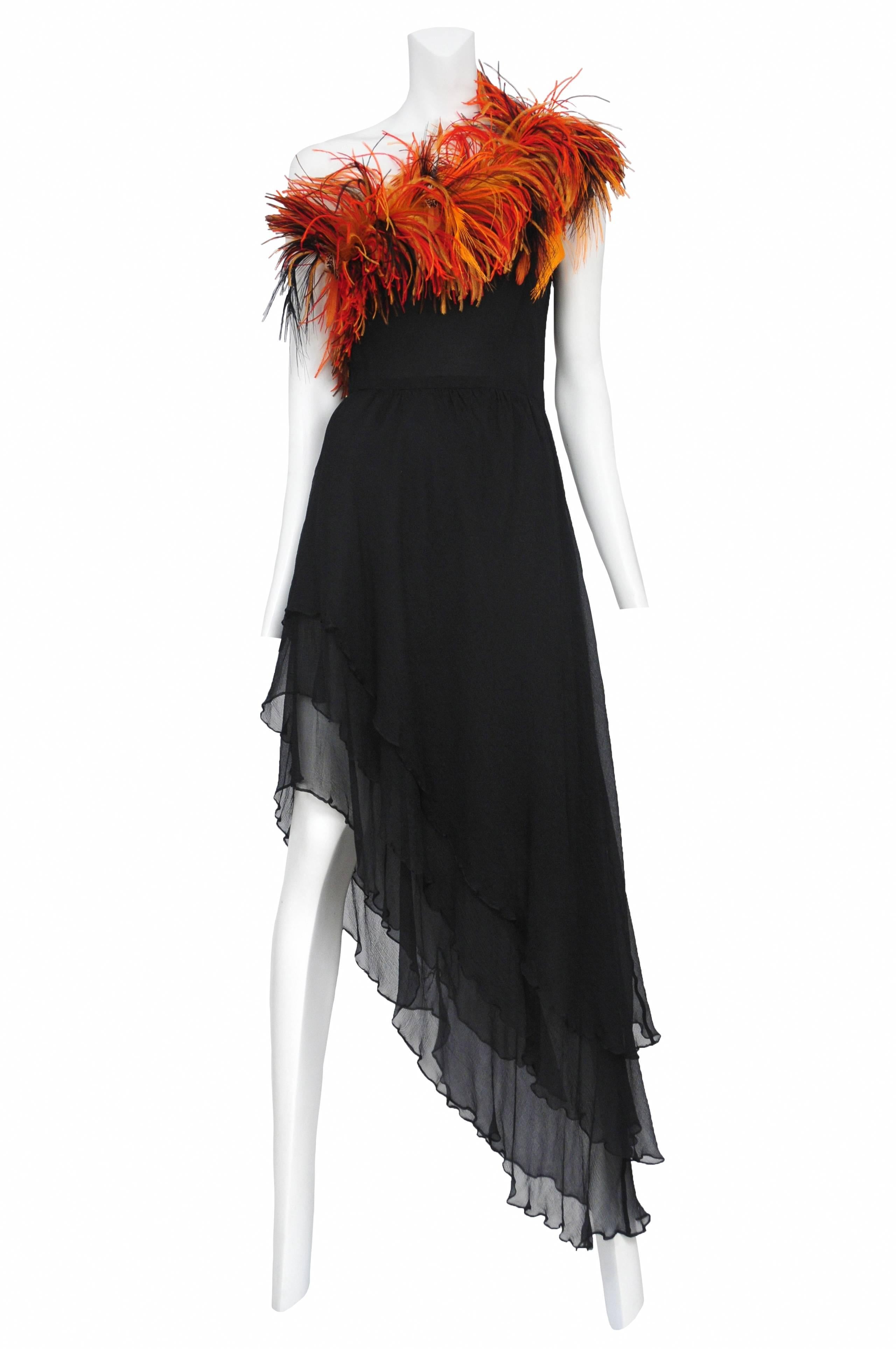 Vintage Yves Saint Laurent black chiffon asymmetrical gown featuring a 3 tiered asymmetrical hem and multicolor ostrich feather trim at the top neckline. Circa 1993.
Please inquire for additional images.