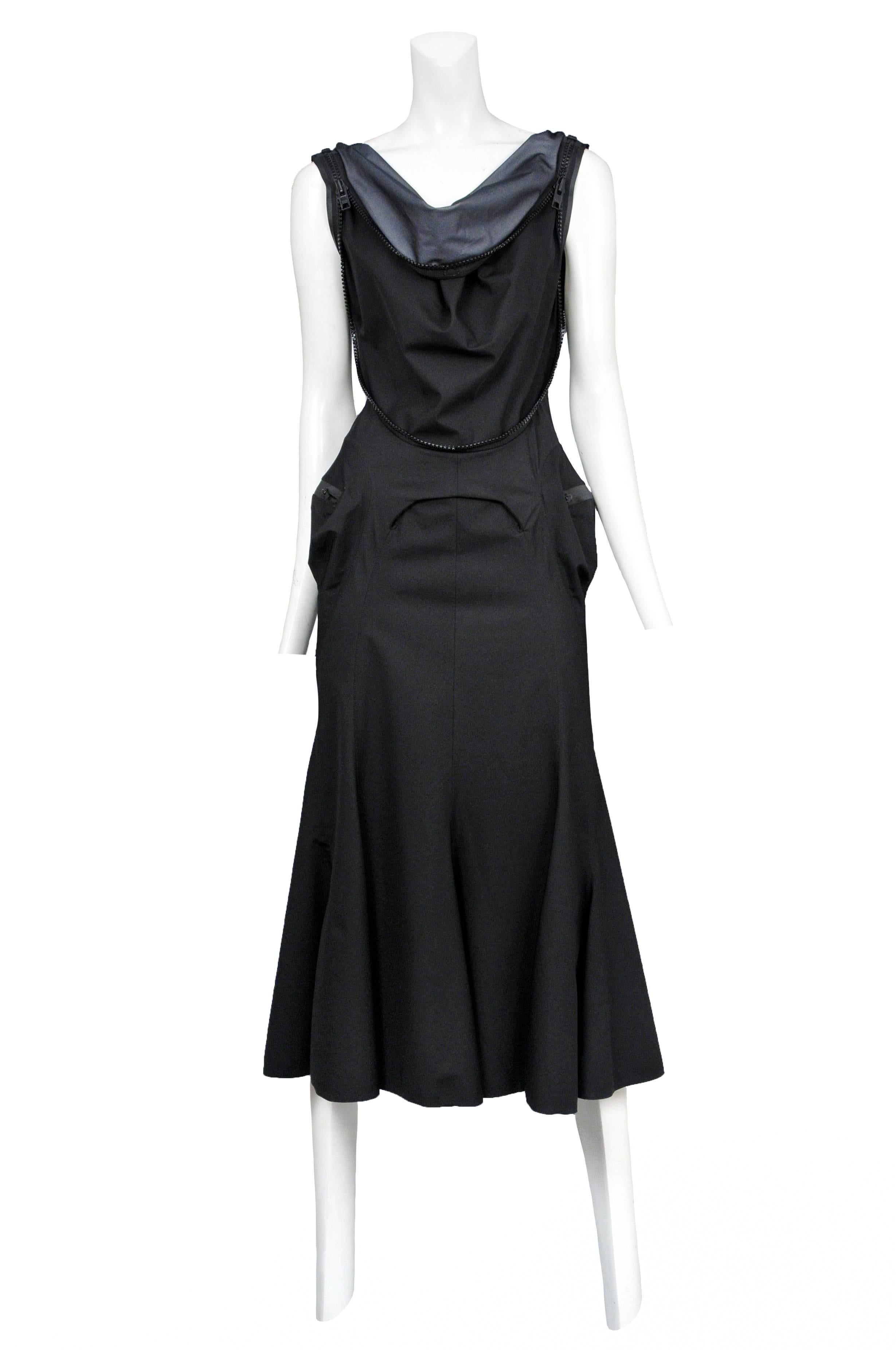 Vintage Junya Watanabe black athletic style dress featuring zipper detailing around the waist and neckline, a fluted skirt, zippered pockets at the hips and exposed grey fabric at the cowl style neckline. Circa 2005.