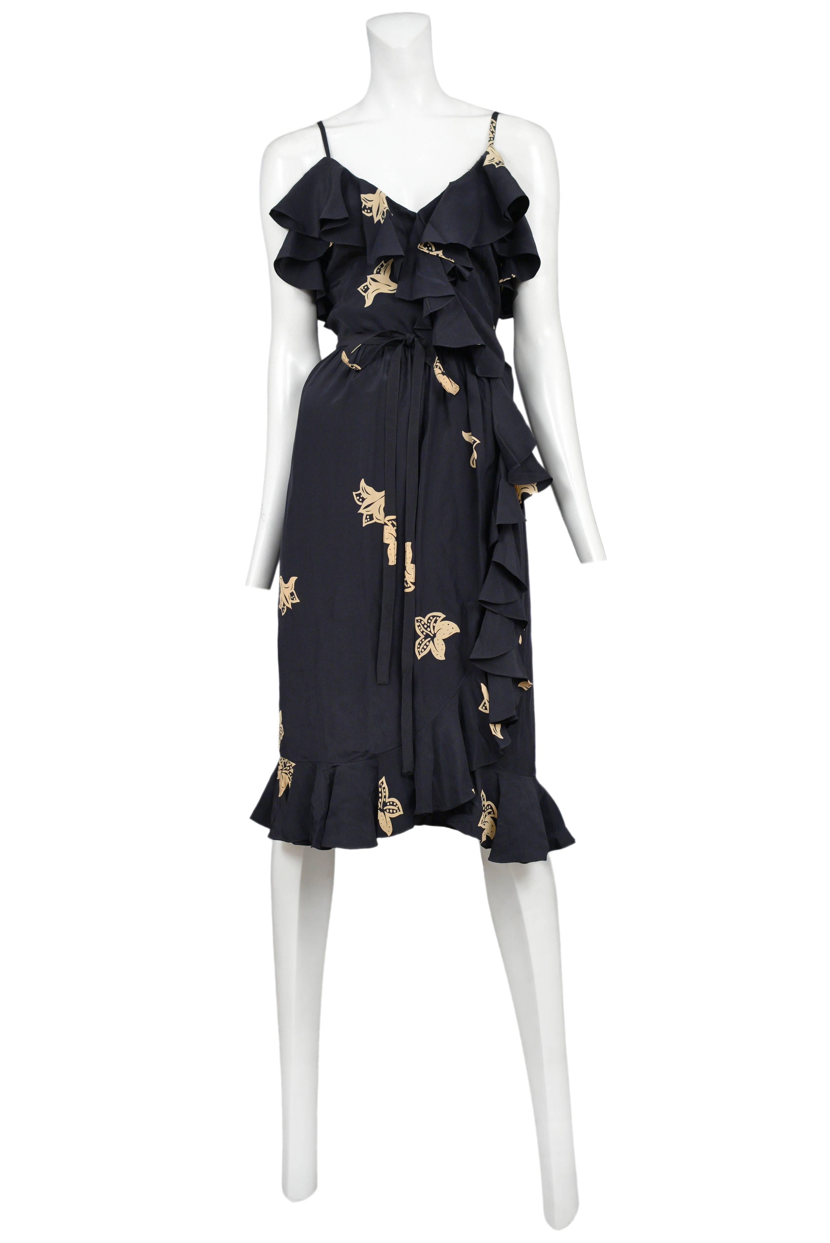 Vintage black silk ruffle dress featuring spaghetti straps, ruffles aligning the v-neckline and hem, matching waist ribbon and an allover cream floral print. The dress comes with a matching ruffle shawl. 
Please inquire for additional images.
