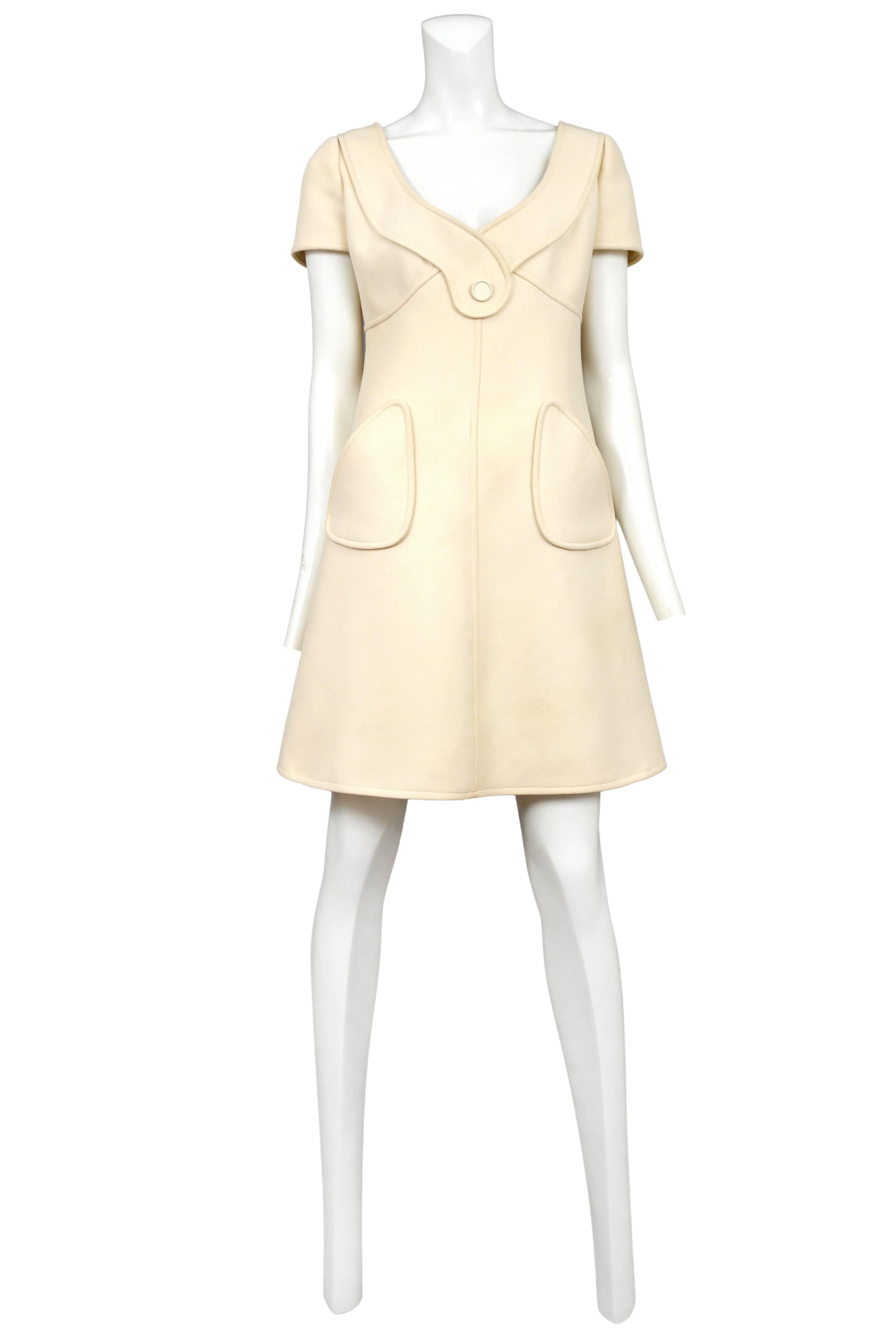 Vintage Courreges cream mod a-line dress featuring short sleeves, a button detail at the front neckline and pockets at the hips.
Please inquire for additional images.