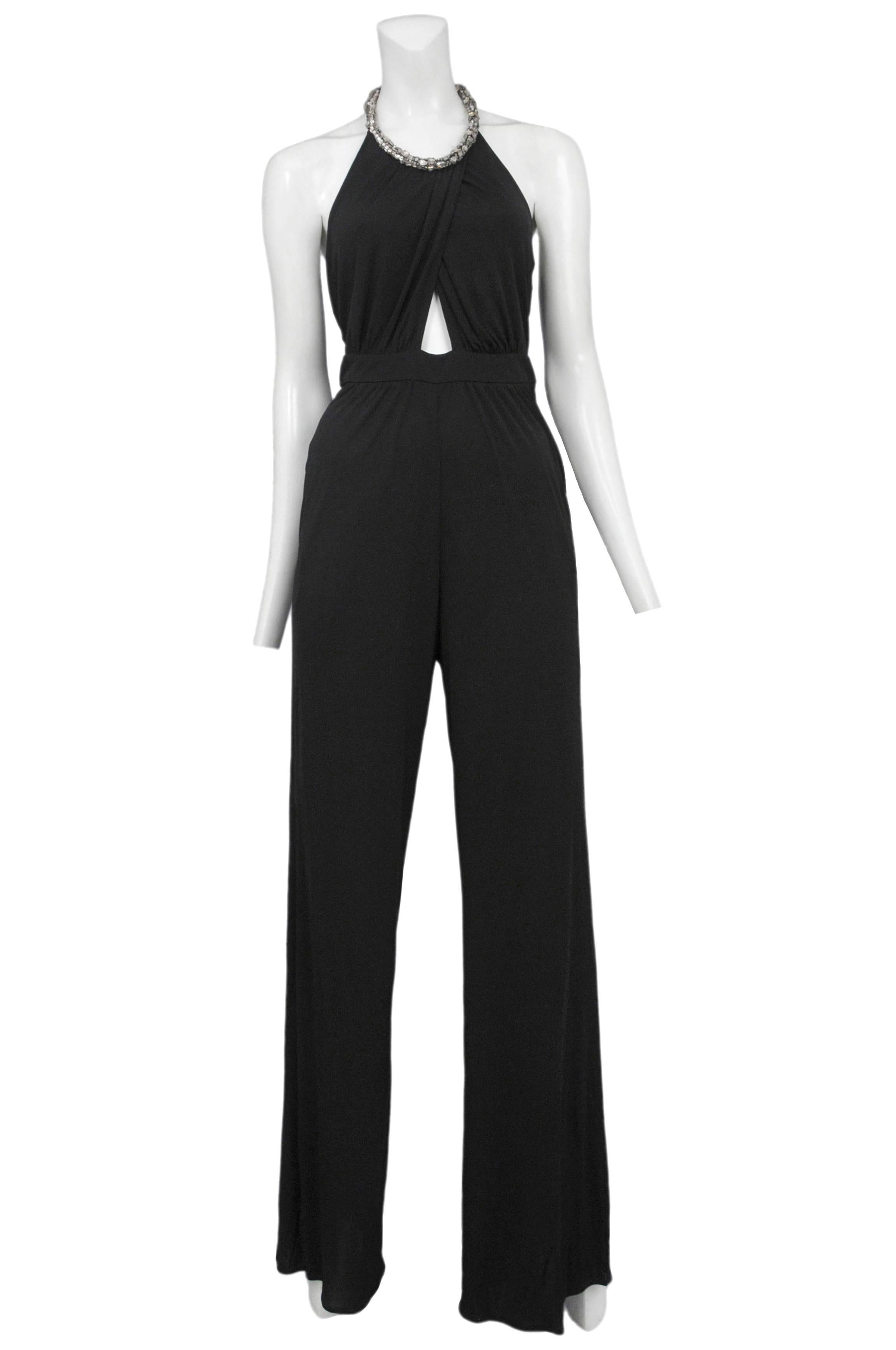 Vintage Roberto Cavalli black jersey jumpsuit featuring a waistband at the high waist, an overlapped halter style top with a built in rhinestone collar closure.
Please inquire for additional images.