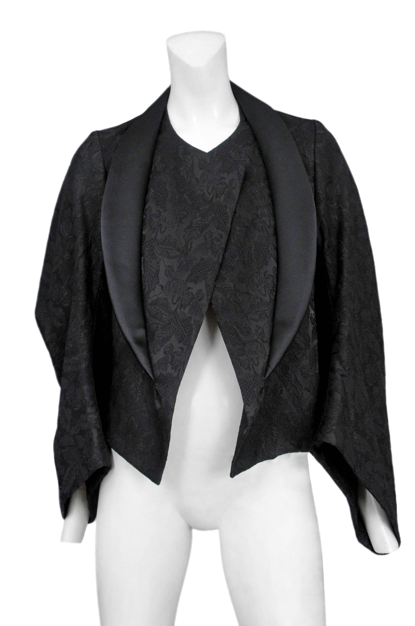 Vintage Comme des Garcons black on black brocade kimono sleeve jacket featuring a black satin collar and a voluminous side profile. Circa Autumn / Winter 2004.
Please inquire for additional images.