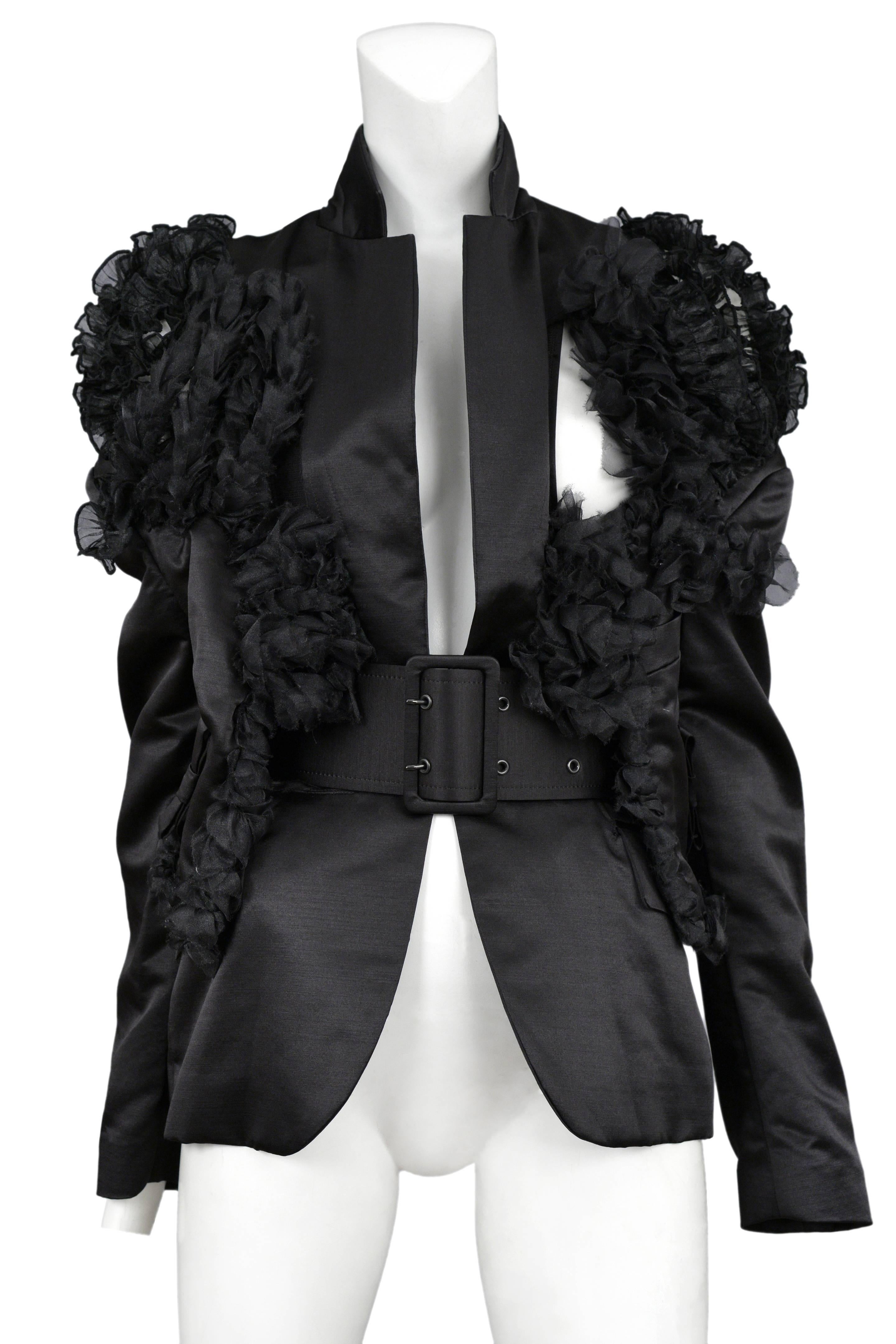 Vintage Comme des Garcons black satin pointed lapel blazer featuring ruffle organza detailing at the shoulders and torso and a matching wide buckle satin belt. Circa Spring /  Summer 2007.
Please inquire for additional images.