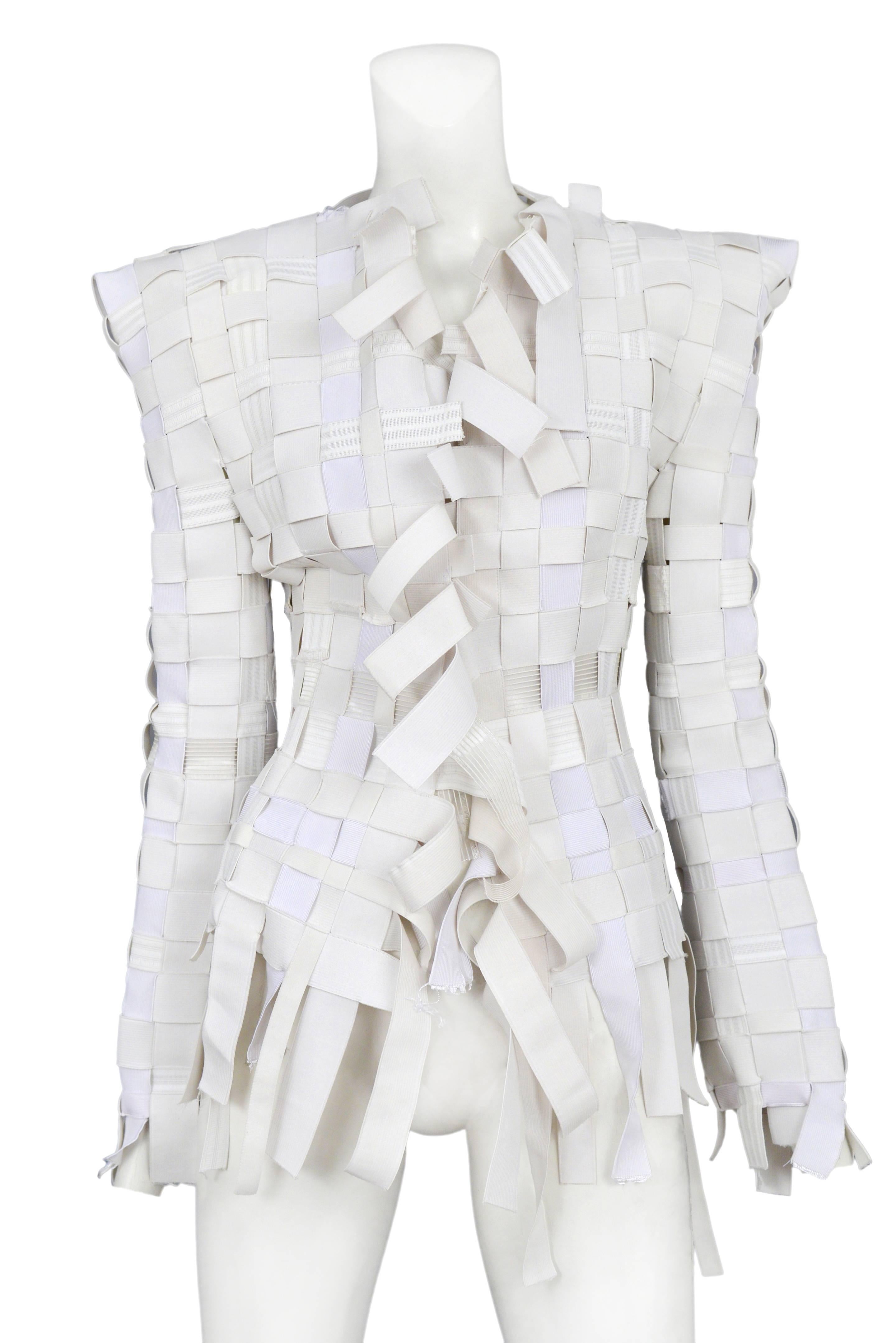 Vintage Maison Martin Margiela white elastic woven blazer featuring various elastics and an uneven hem at the front opening, hem and cuffs. Circa 2008.
Please inquire for additional images.