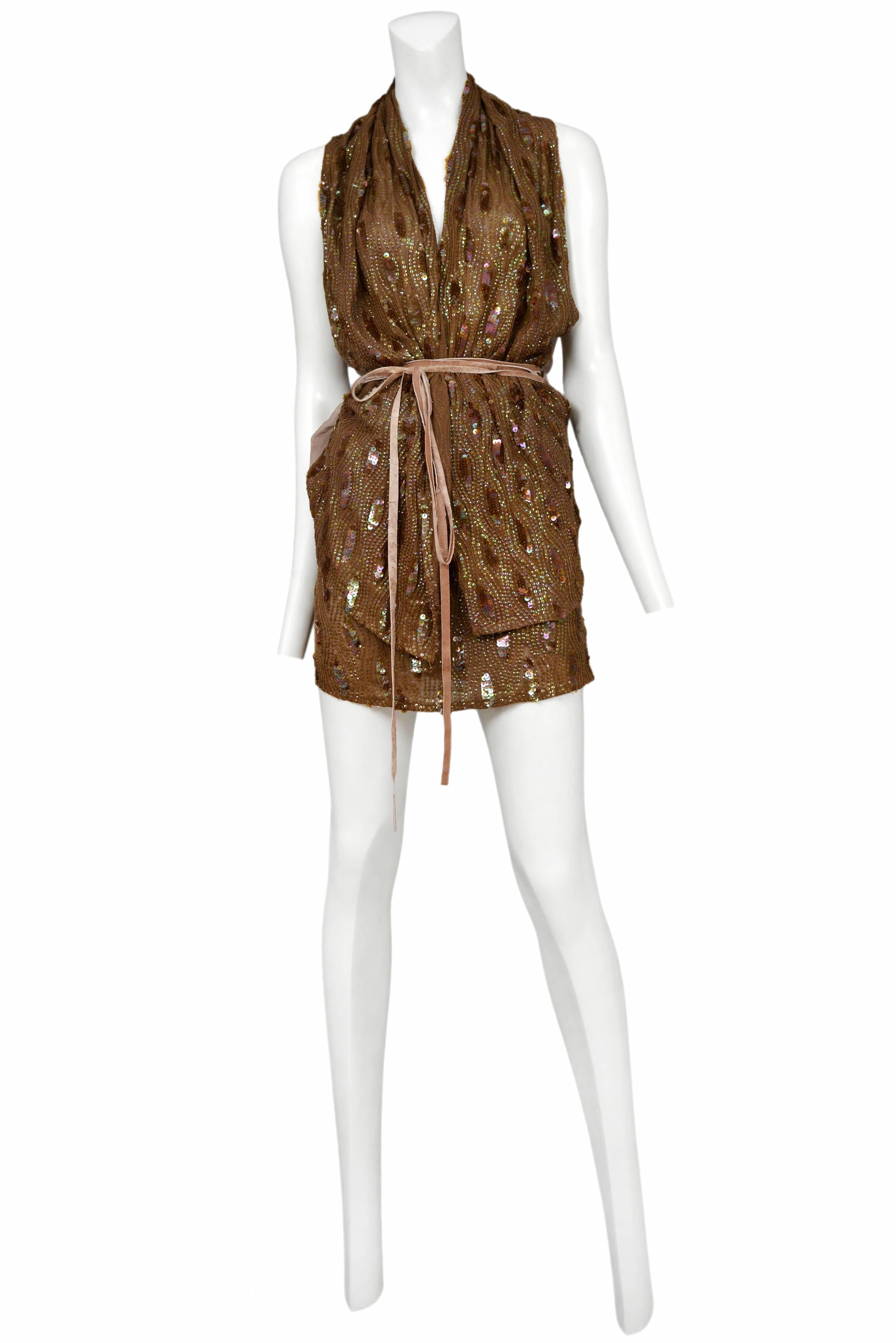 Vintage Ann Demeulemeester ensemble featuring a brown sequin adorned wrap top with sheer brown chiffon at the back and stays in place with a brown suede tie and matching mini skirt.
Please inquire for additional images.