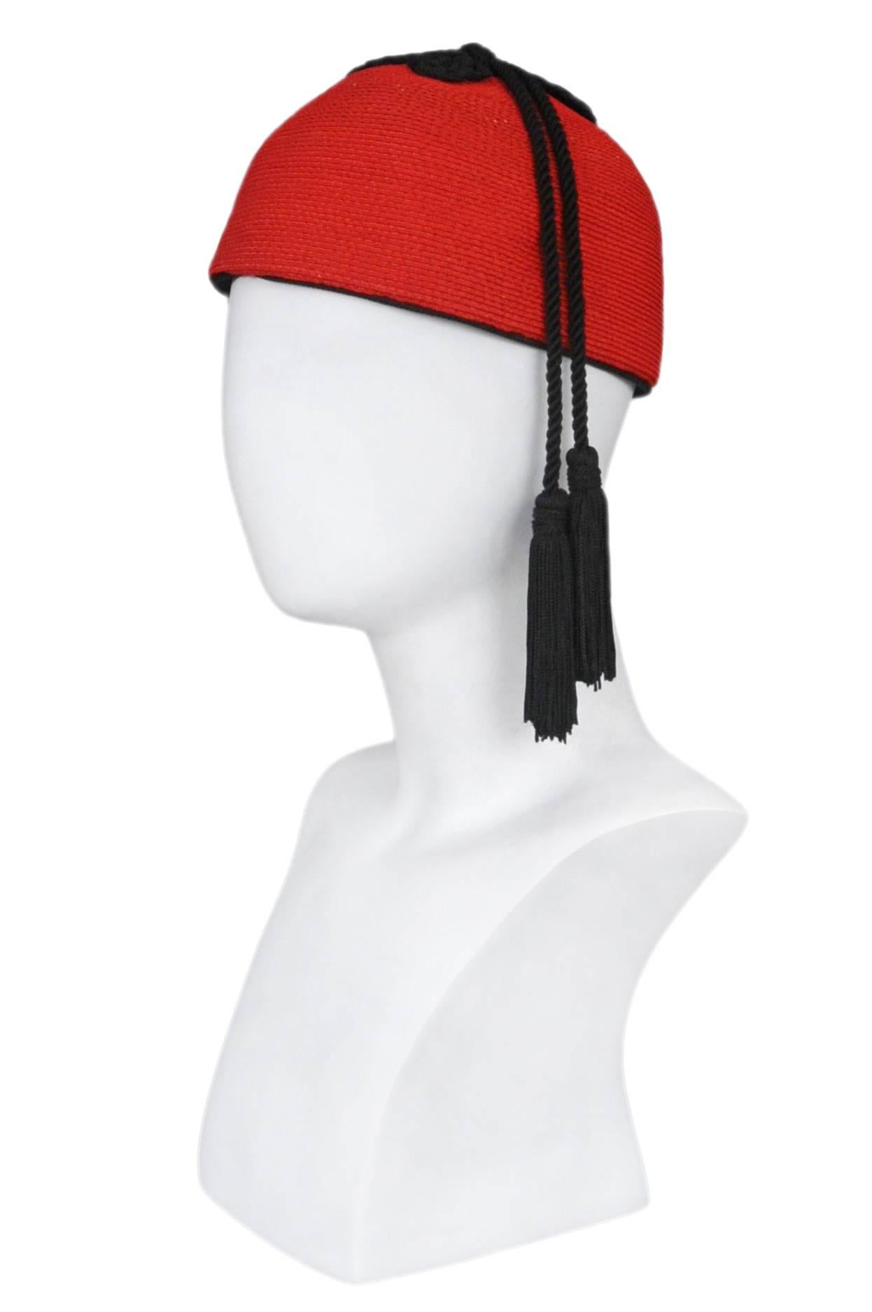 Resurrection Vintage is excited to offer a vintage Yves Saint Laurent red raffia cap hat with two black tassels and trim. Circa 1976. Iconic and in excellent condition. 

Yves Saint Laurent
Size: Diameter 7.5 in, Height 4.5 in, Tassel Length 12 in.