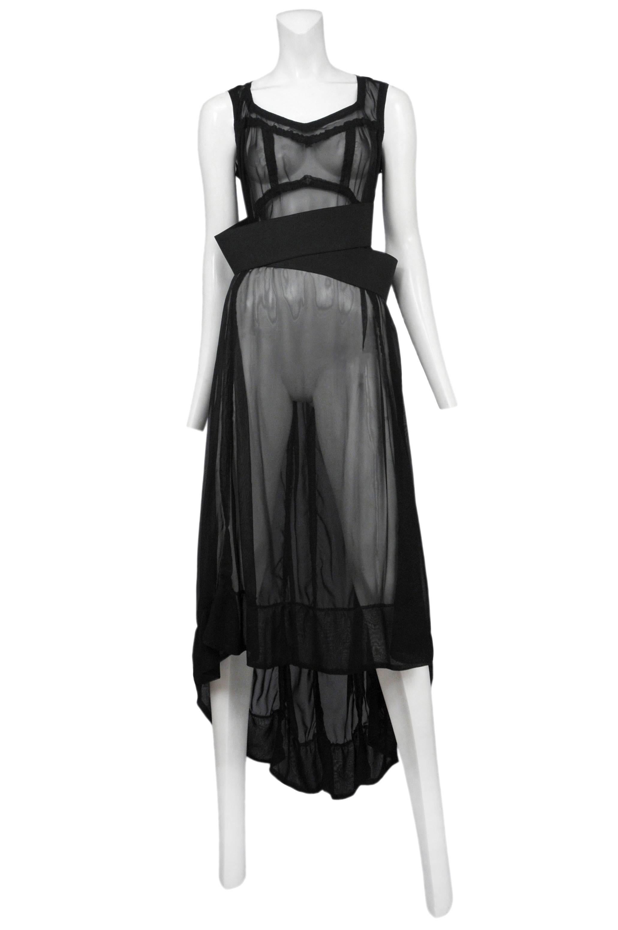 Vintage Commes des Garcons black sheer lingerie style slip dress featuring two wide black elastic bands at the waist and a hem that is longer in the back and shorter in the front. Circa Spring / Summer 2010.
Please inquire for additional images.