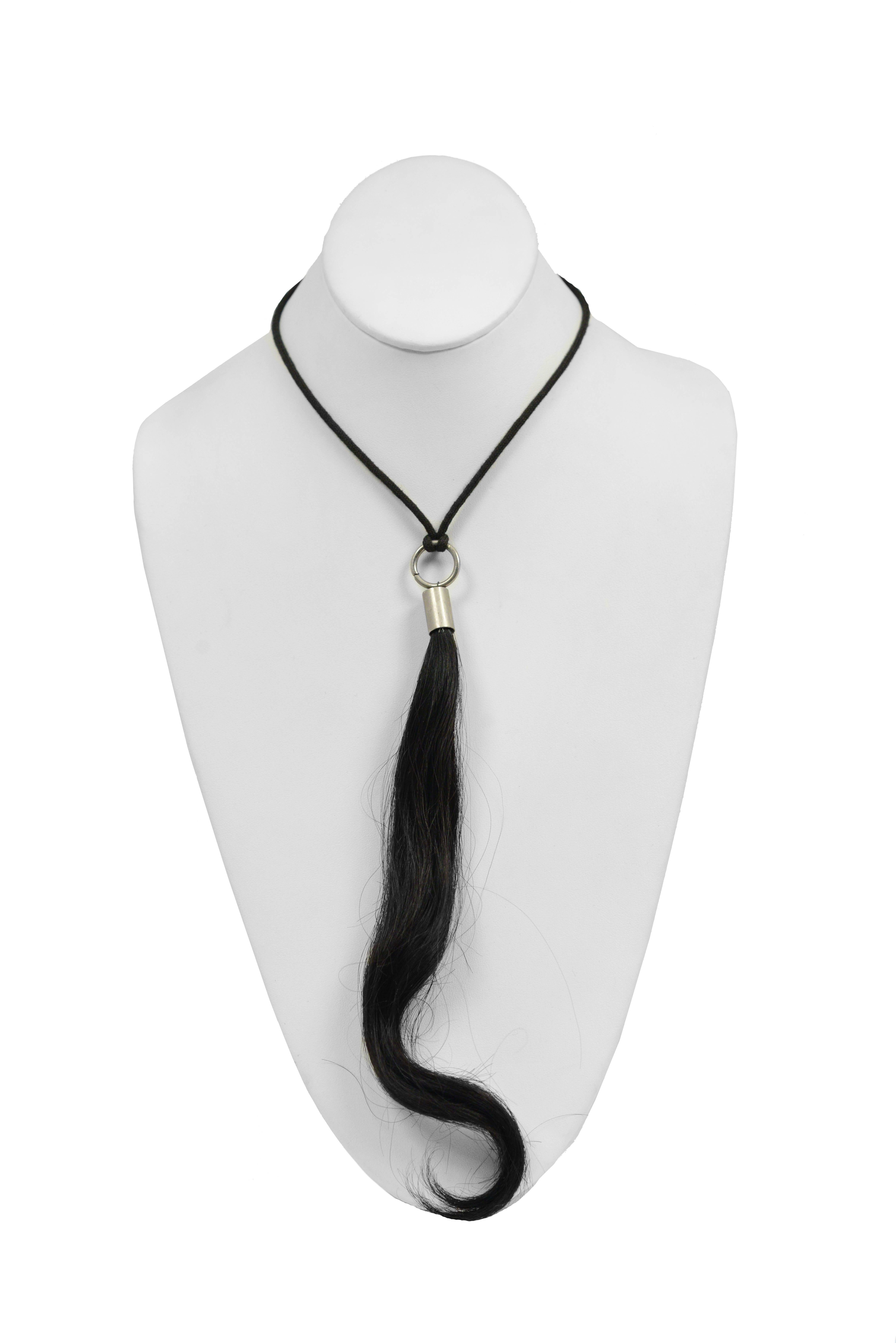 Vintage Maison Martin Margiela black necklace featuring a strand of black hair that hangs from a metal pendant. Circa 1999.
Please inquire for additional images.