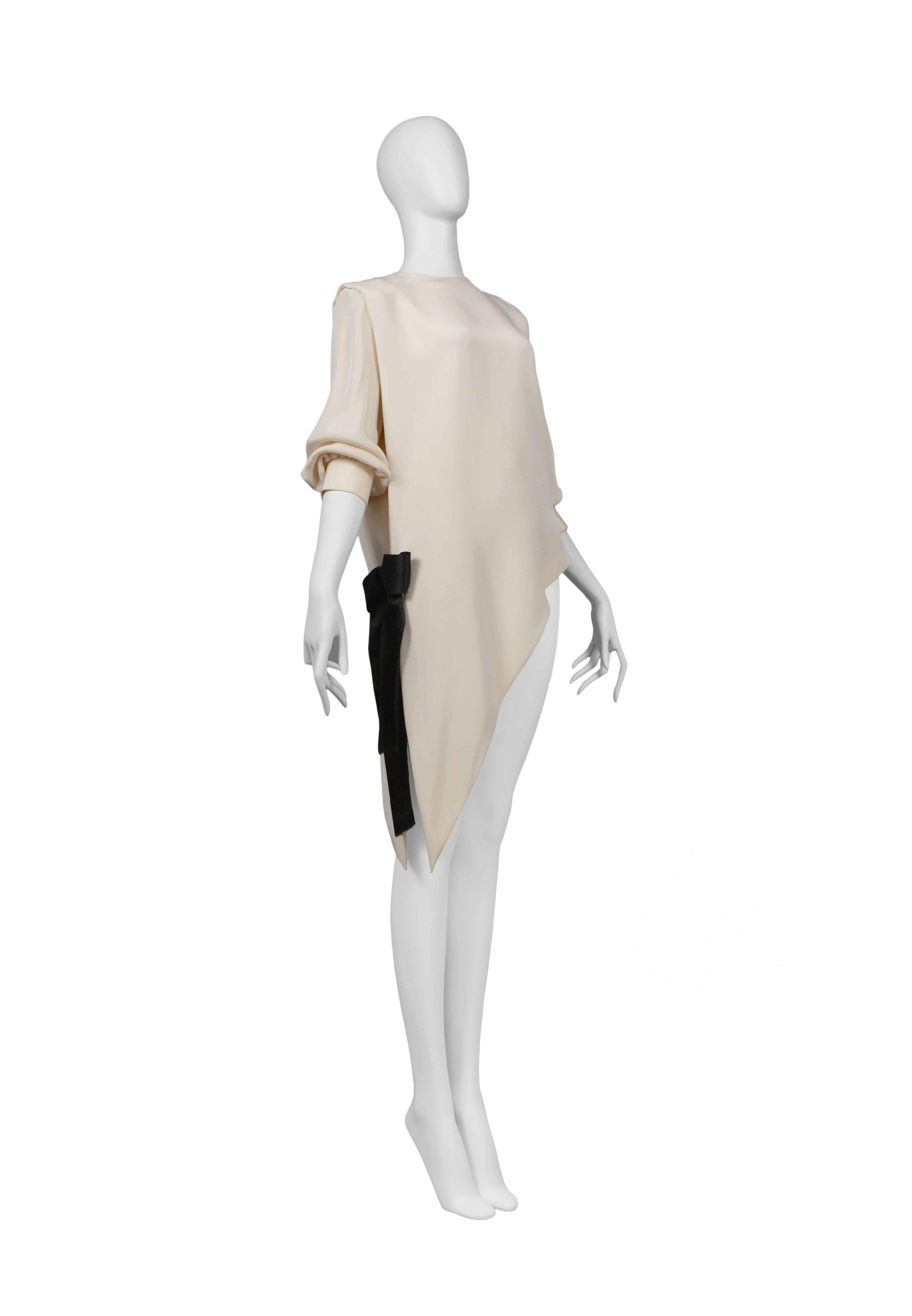 Pierre Cardin Couture off-white silk asymmetrical dress with black bow at hip. Circa, 1986-1993.