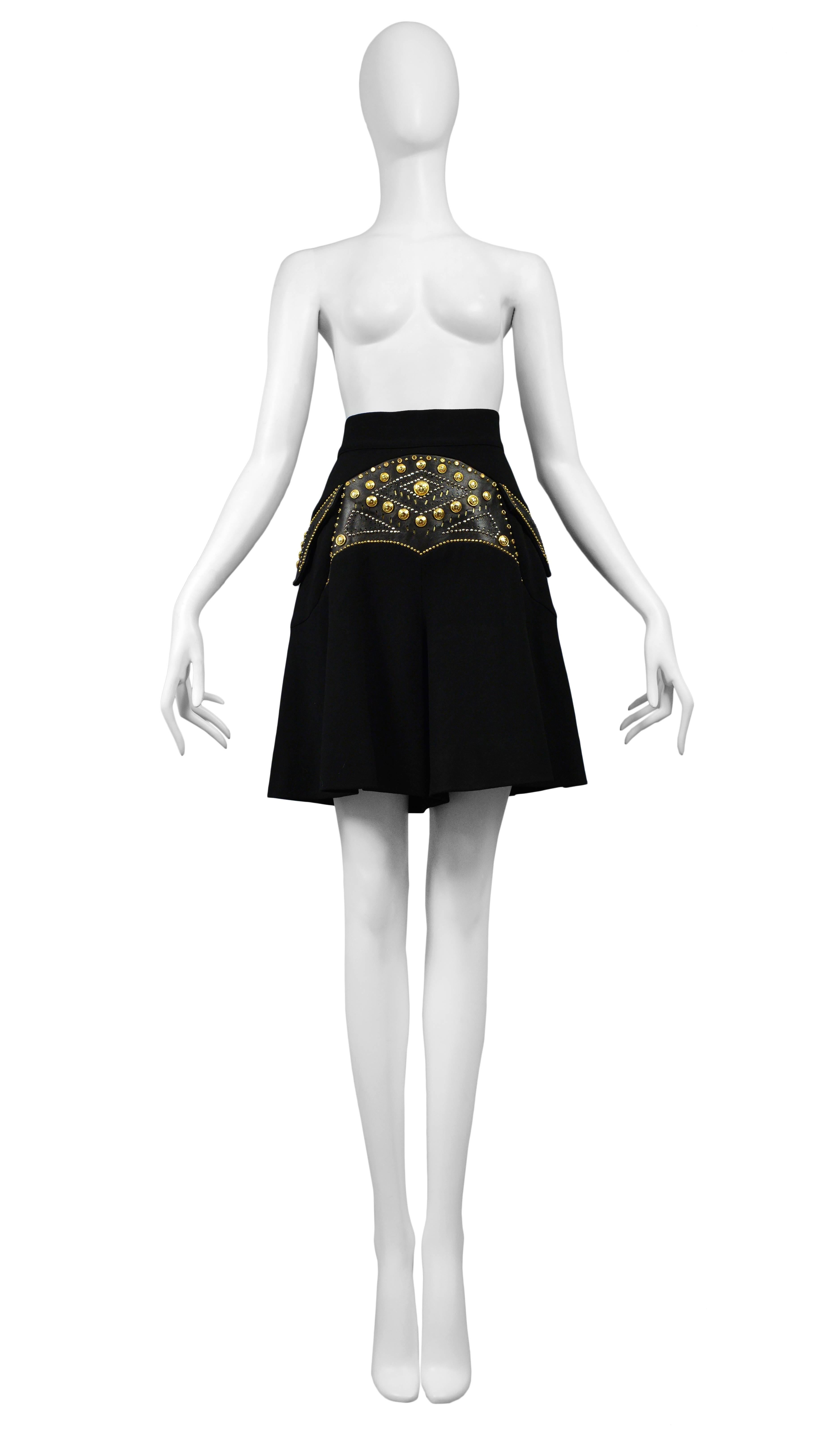 Vintage Versace black skort featuring leather paneling at the front with gold stud detailing.