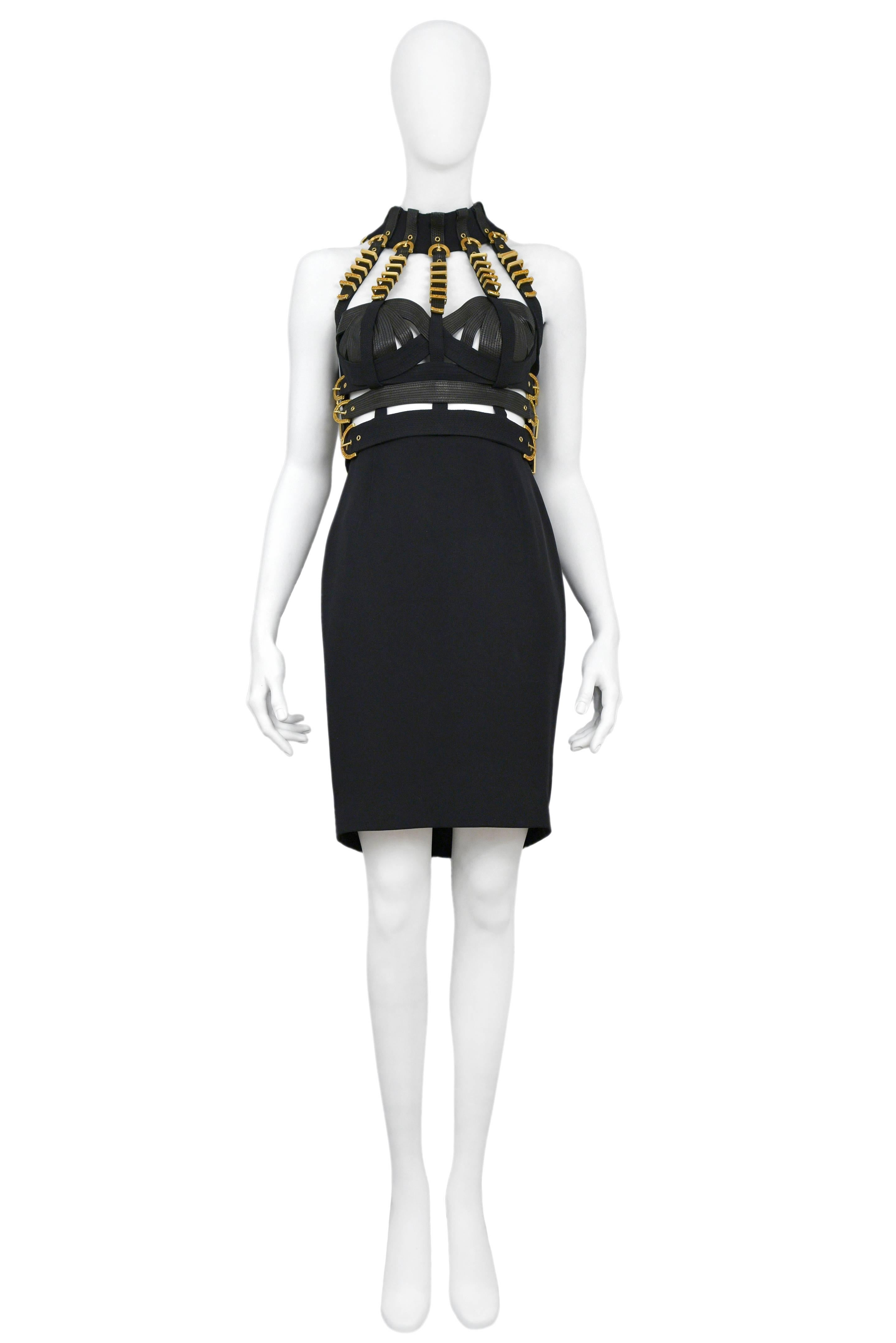 Resurrection is pleased to offer an important bondage dress from Gianni Versace's Fall 1992 collection, Miss S&M. The dress features a bondage style quilted bustier and skirt with gilt buckled straps. Tiny amber colored rhinestones decorate selected