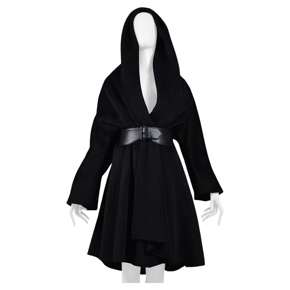 Resurrection Vintage is thrilled to offer a vintage statement Thierry Mugler black hooded cape coat featuring a dramatic hood and collar with folded detail at front, invisible button front closure, side pockets, gathered fabric on hood, long sleeves