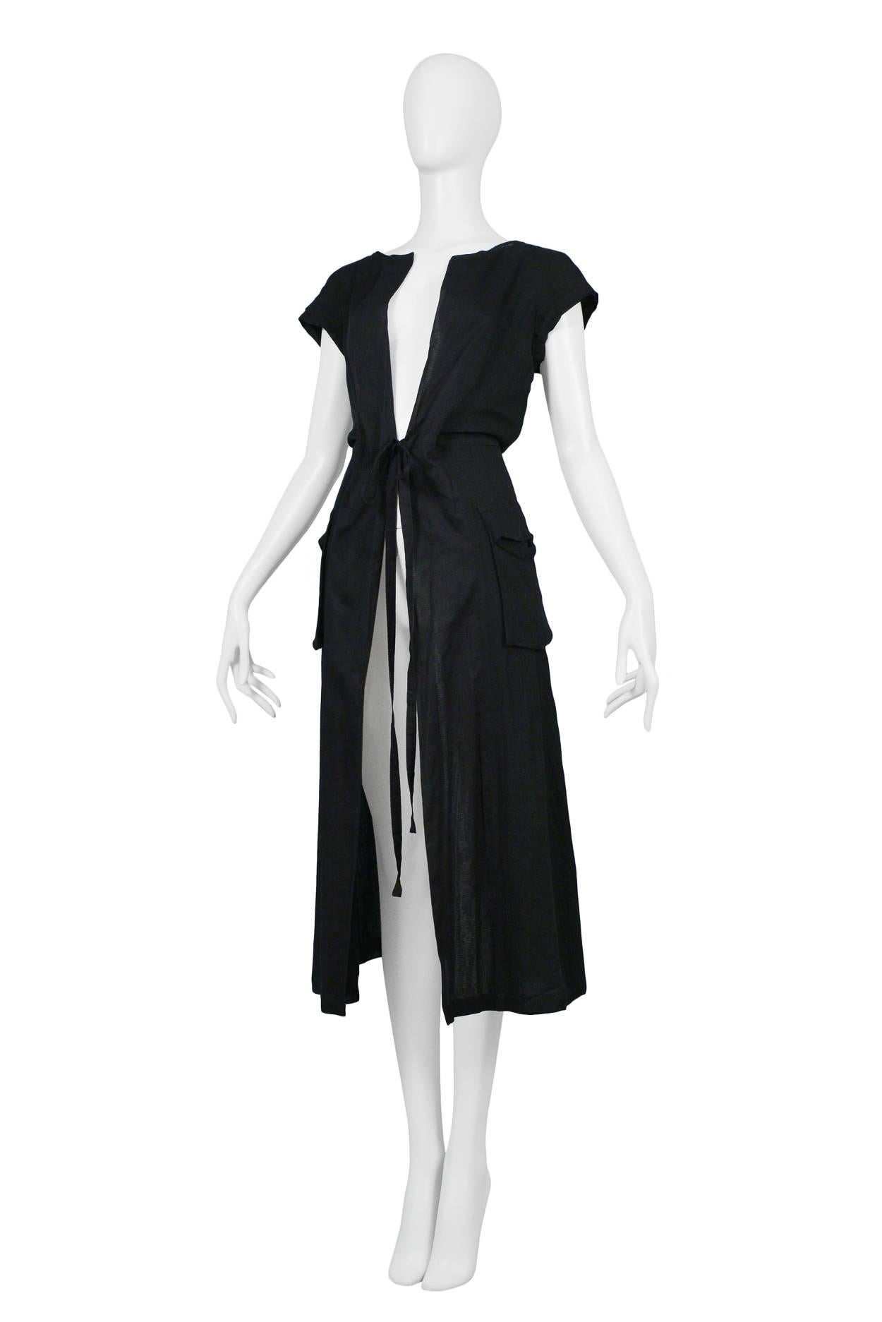 Resurrection Vintage is excited to offer a vintage Comme des Garcons black linen duster featuring front pockets, tie front, cap sleeves, and a-line skirt. 

Comme Des Garcons
Size: Small
Measurements: Bust 32
