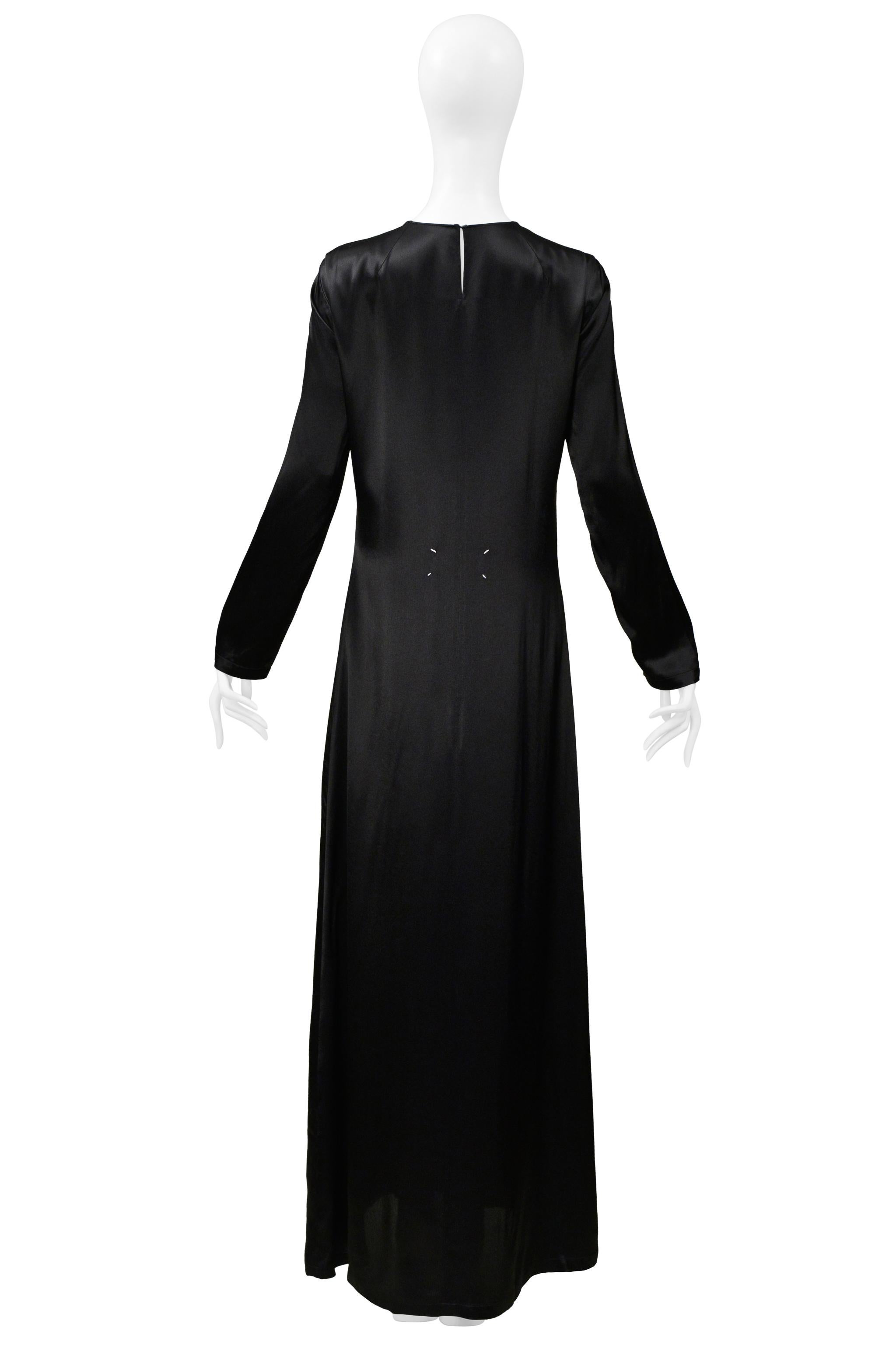 Resurrection Vintage a le plaisir de présenter une robe de soirée vintage en satin noir de la Maison Martin Margiela avec une encolure haute, des emmanchures circulaires, des manches longues, un corps décontracté avec une légère forme en A à
