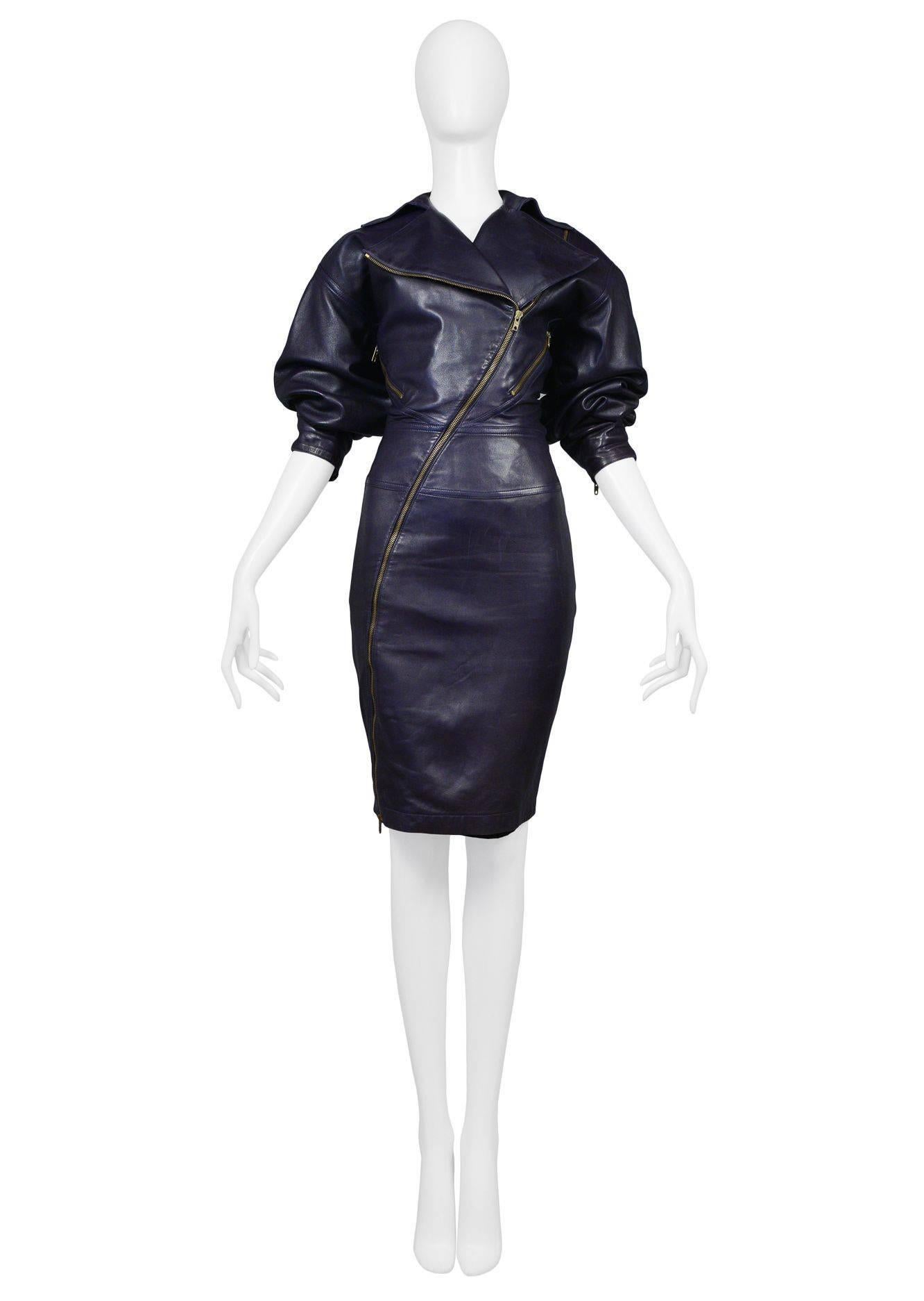 Iconic Azzedine Alaia eggplant leather motorcycle inspired zipper dress. Dress is made of the finest French lambskin leather and features brass toned zippers across body, slanted zipper pockets at waist, and zippers at back of skirt. Oversized