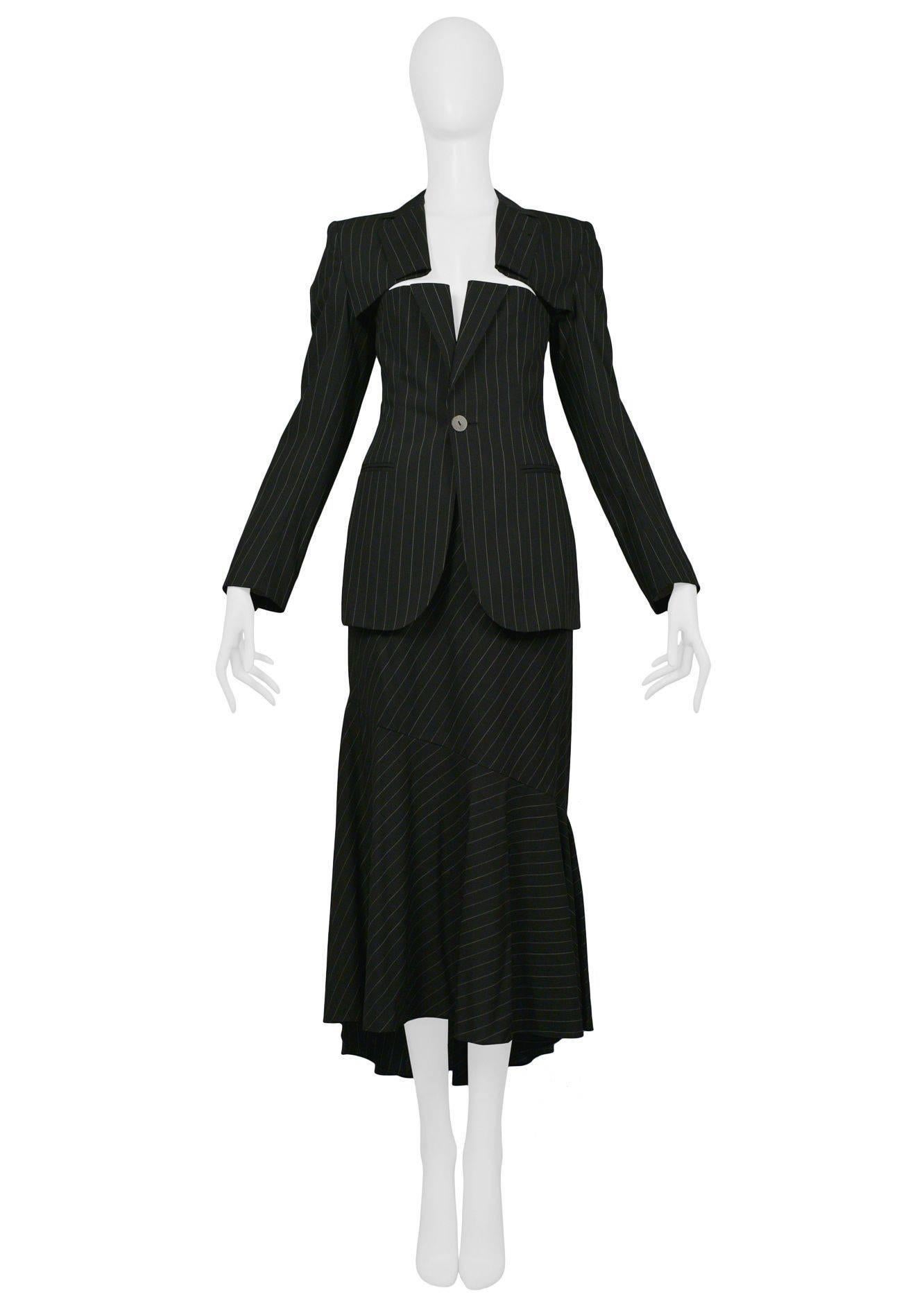 Vintage 1990's Jean Paul Gaultier pinstripe skirt ensemble. Jacket features slits at breast and fitted body. Skirt features asymmetrical ruffle detail.
