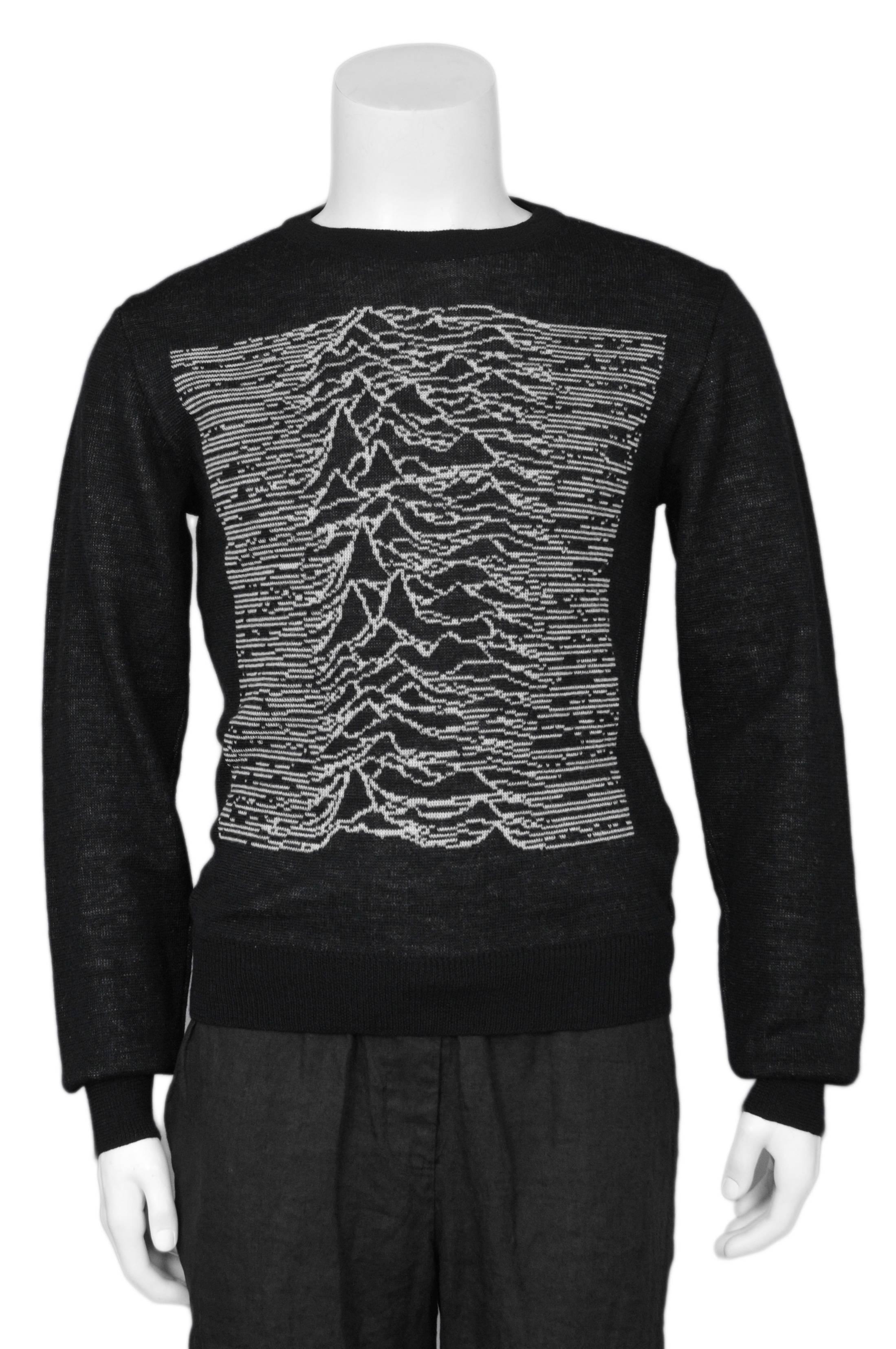 Schwarzer Strickpullover mit weißer Grafik aus der Zusammenarbeit von Raf Simons und Peter Saville. Der Pullover zeigt eine von Saville entworfene Grafik für das kultige Album Unknown Pleasures der britischen Band Joy Division aus den 1980er Jahren.