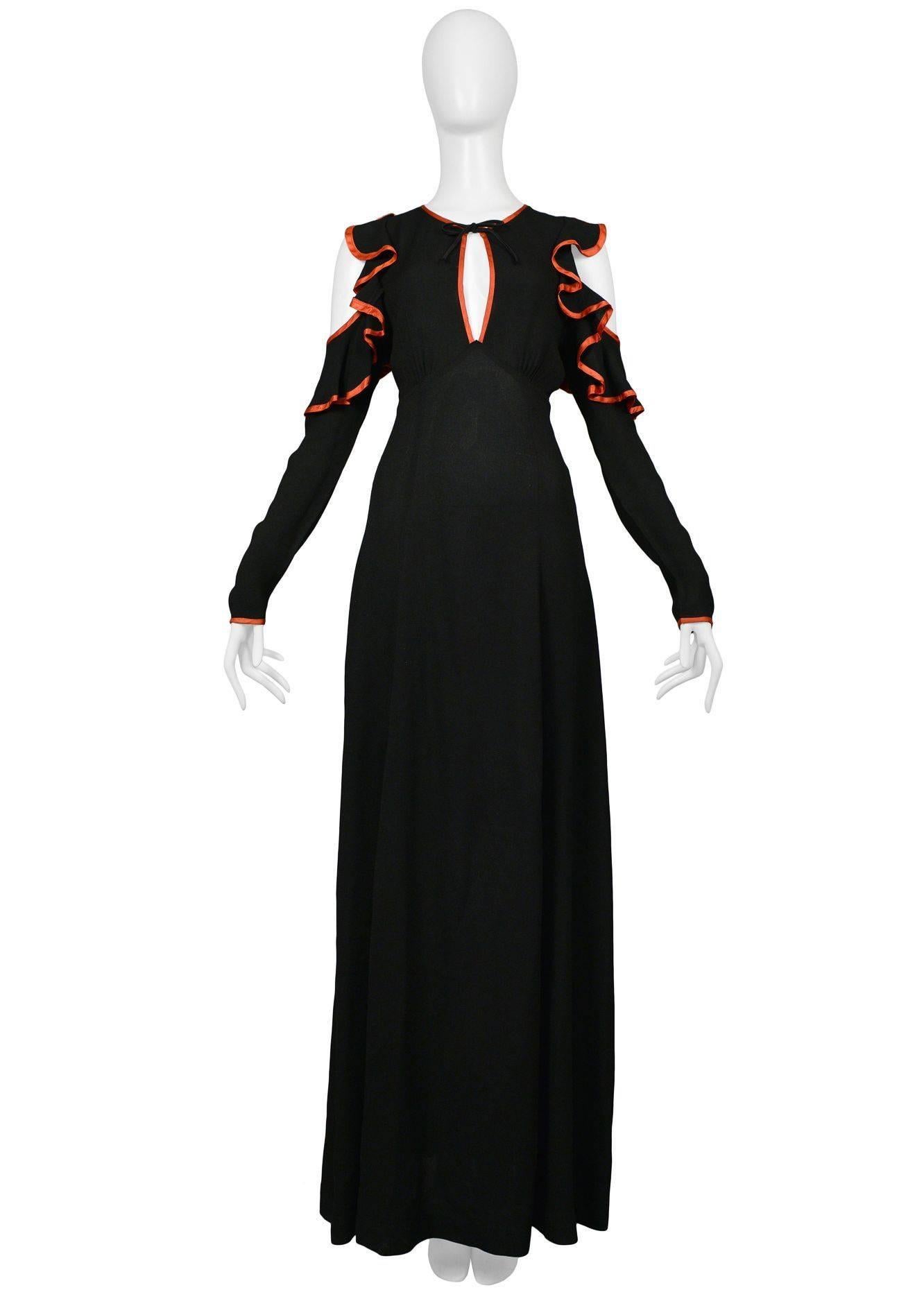 Iconic vintage Ossie Clark black crepe gown with open back, exposed shoulders, and red satin ribbon trim that ties at neck.