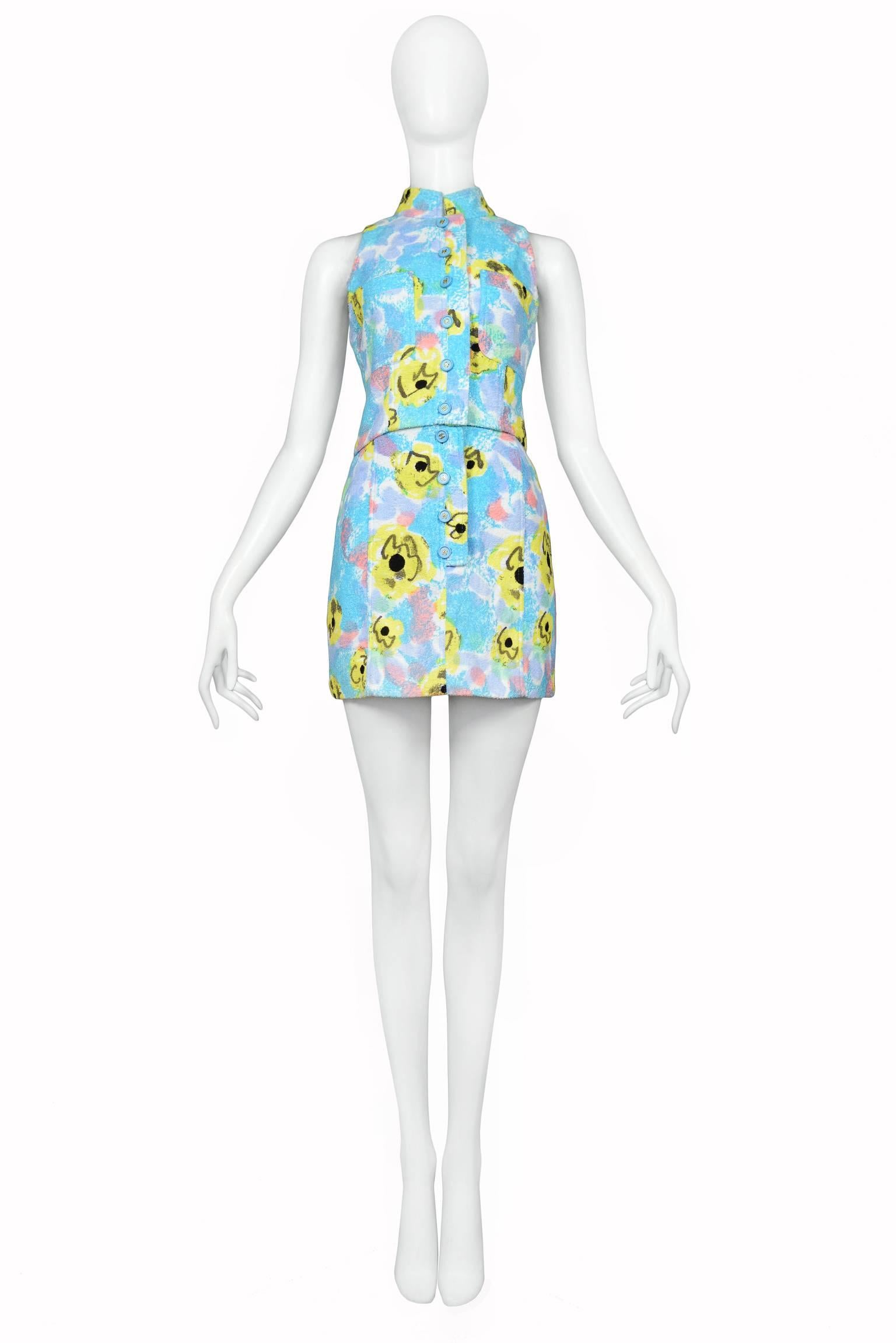 Vintage Chanel blue floral Pop Art print crop top and mini skirt ensemble. Blue buttons feature "CC" logos. Matching hat and hologram cuff as seen on runway also available. Collection SS 1997. 